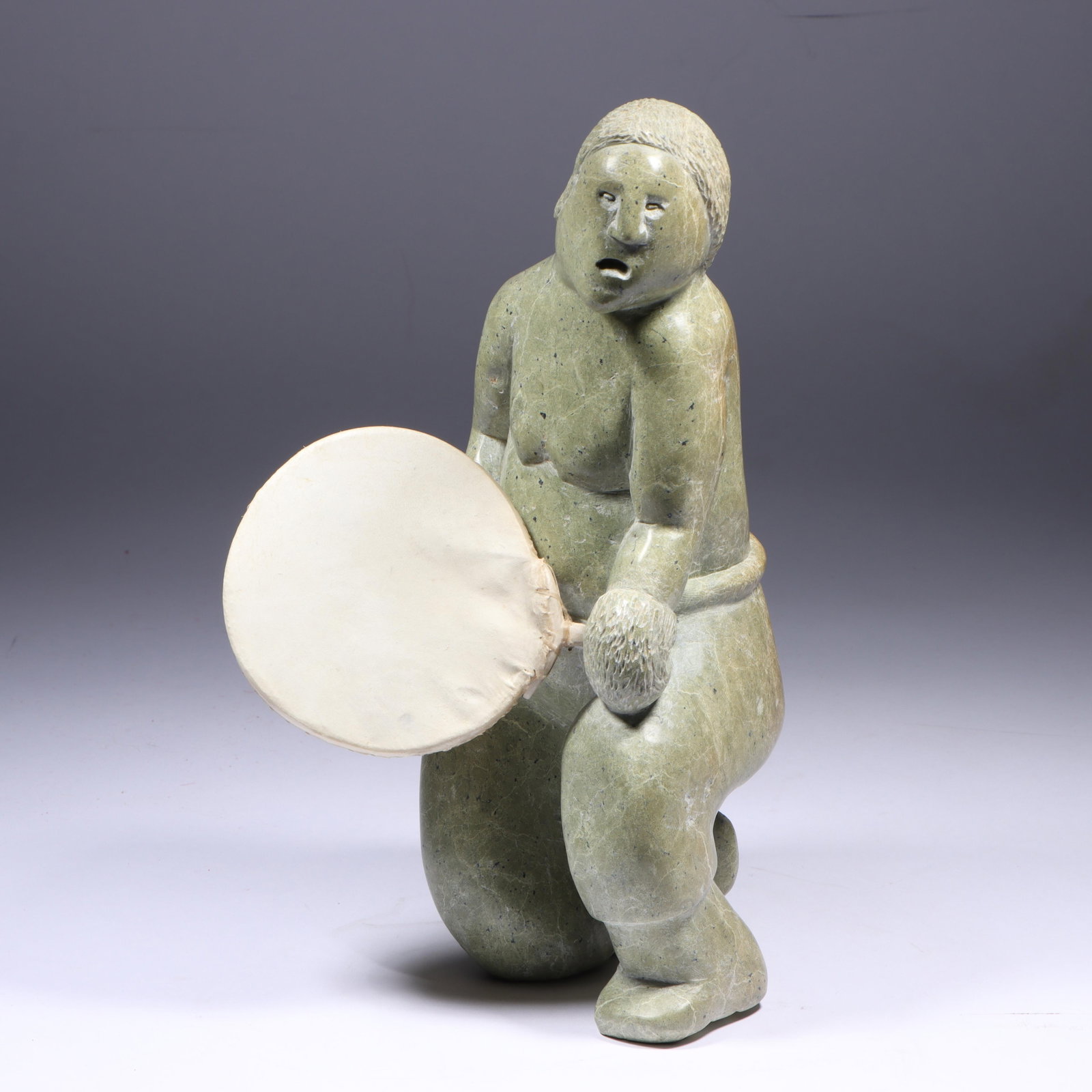Ikey Milton, Pond Inlet, N.W.T. / Canadian / Inuit (b. 1949), Large 12inch Drum Dancer, 1982, carved: Ikey Milton Pond Inlet, N.W.T. / Canadian / Inuit (b. 1949) Large 12inch Drum Dancer, 1982 carved soapstone / serpentine with bone accessories Canadian Eskimo art label and card present. 12"H x 7"W