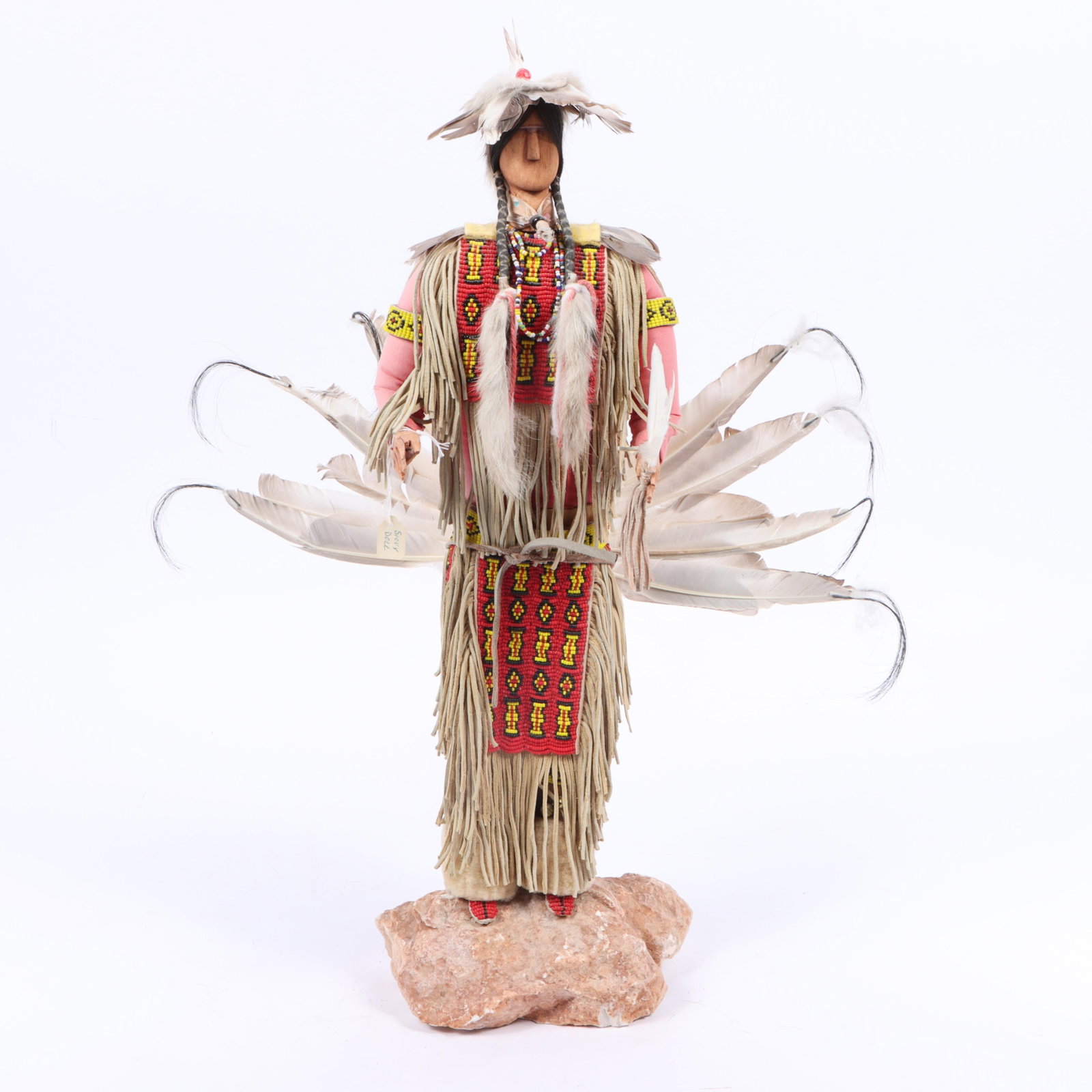 Randy Charging Bear, Native American doll with beadwork and leather fringe costume and feathers,: Randy Charging Bear Native American doll with beadwork and leather fringe costume and feathers carved wood on rock base signed and numbered under base. 23"H x 18"W