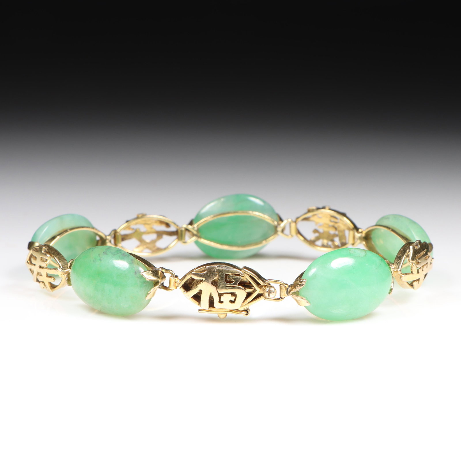 14K Yellow Gold Soft Apple Green Oval Chinese Jadeite Jade Stone Bracelet with Decorative Chinese: 14K Yellow Gold Soft Apple Green Oval Chinese Jadeite Jade Stone Bracelet with Decorative Chinese Symbol Links 12.85 dwt. The jadeite has fine semi-translucency in good condition with no chips, or nic