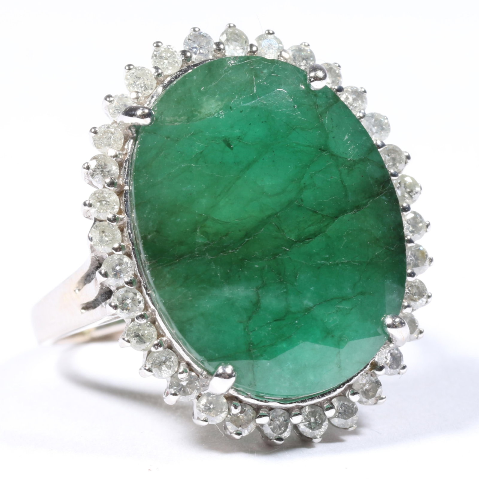 14K White Gold 12.10 Carat Emerald Ring Surrounded by a Diamond Halo Size 8 1/2: 14K White Gold 12.10 Carat Emerald Ring Surrounded by a Diamond Halo 5.69dwt. 1 - 20mm x 16mm oval emerald, approx. 12.10ct. 32 - approx. .64tcw., J-K, I2-I2. The ring has a sizing bar. The purchase o