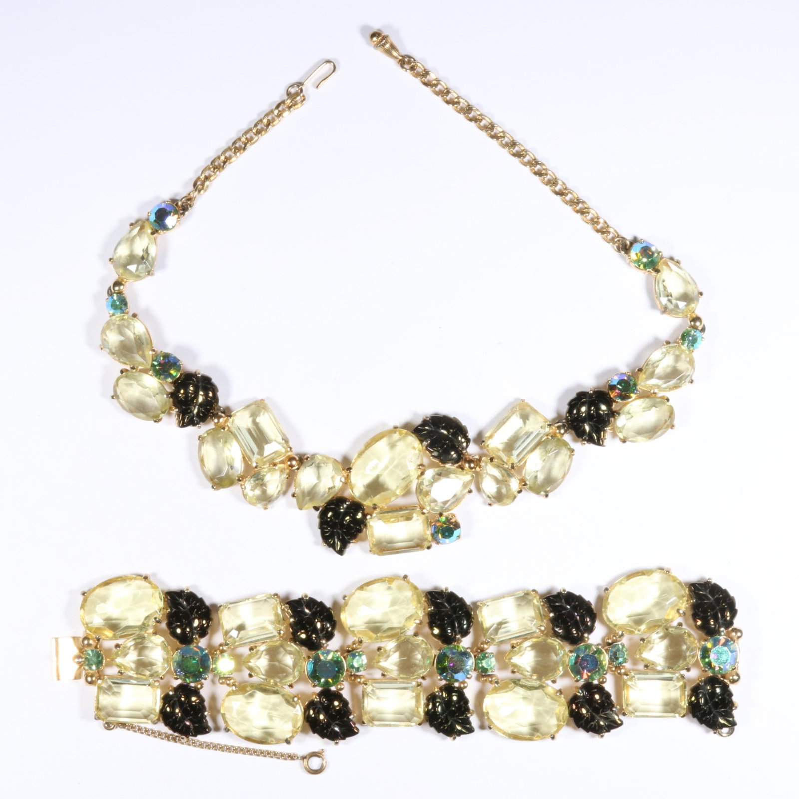 Schiaparelli book piece demi parure with large lemon yellow jewels, molded glass leaves, and aurora: Schiaparelli book piece demi parure with large lemon yellow jewels, molded glass leaves, and aurora borealis rhinestones, includes necklace and bracelet. "Fabulous Fakes" by Carole Tanenbaum, pg. 131 