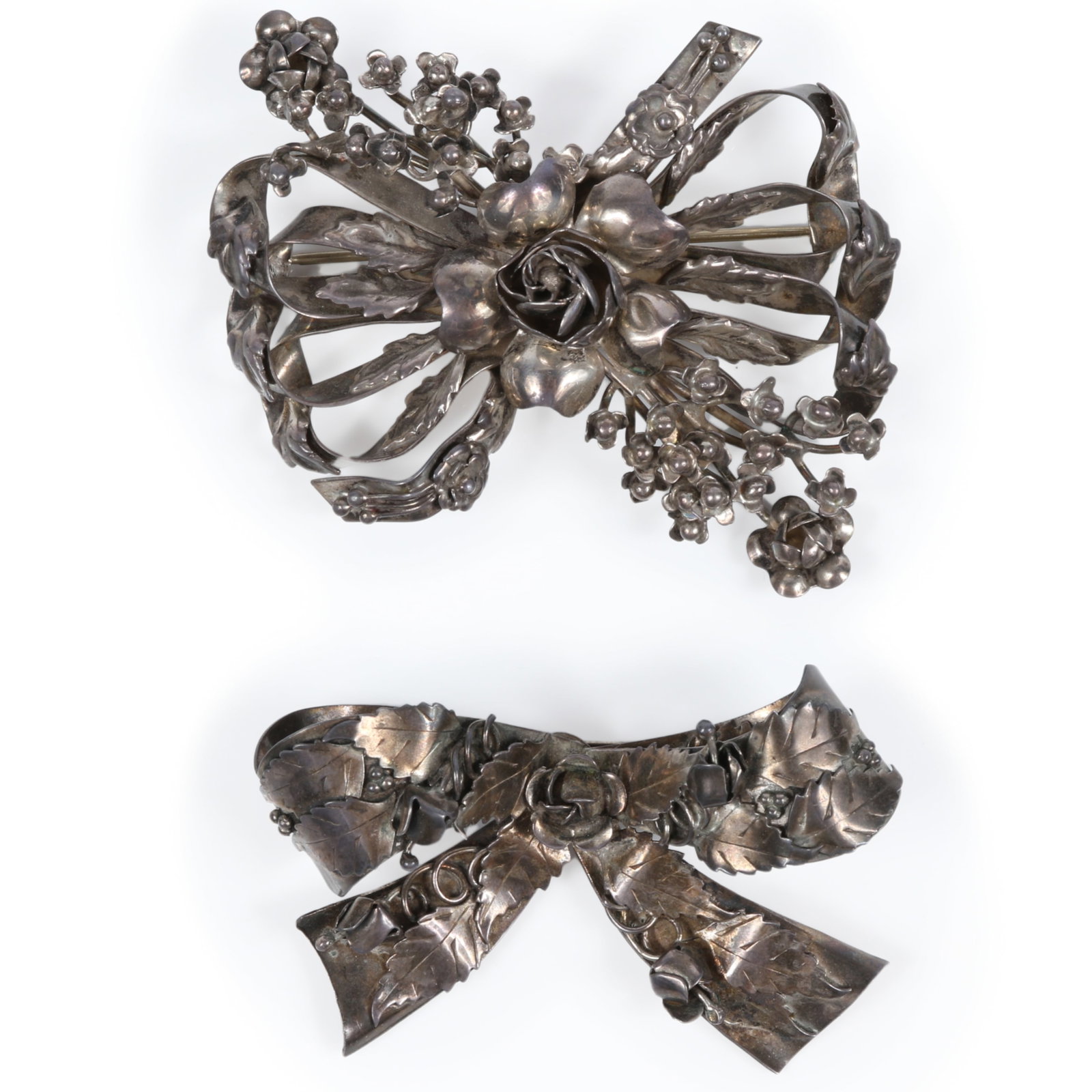 Pair of large Hobe 1940's sterling silver bow brooches with floral details 2 3/4"H x 3"W (largest): Pair of large Hobe 1940's sterling silver bow brooches with floral details Smaller brooch only marked "sterling" 2 3/4"H x 3"W (largest)