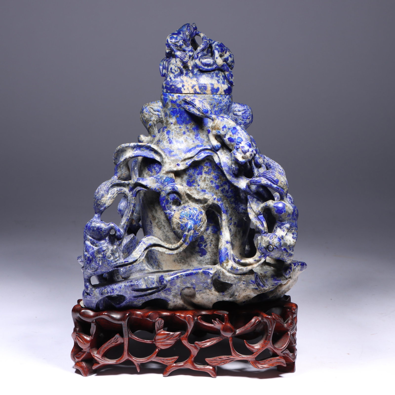 Chinese Qing Dynasty carved lapis lazuli urn form vessel sculpture with foo dog motif on display: Chinese Qing Dynasty carved lapis lazuli urn form vessel sculpture with foo dog motif on display stand