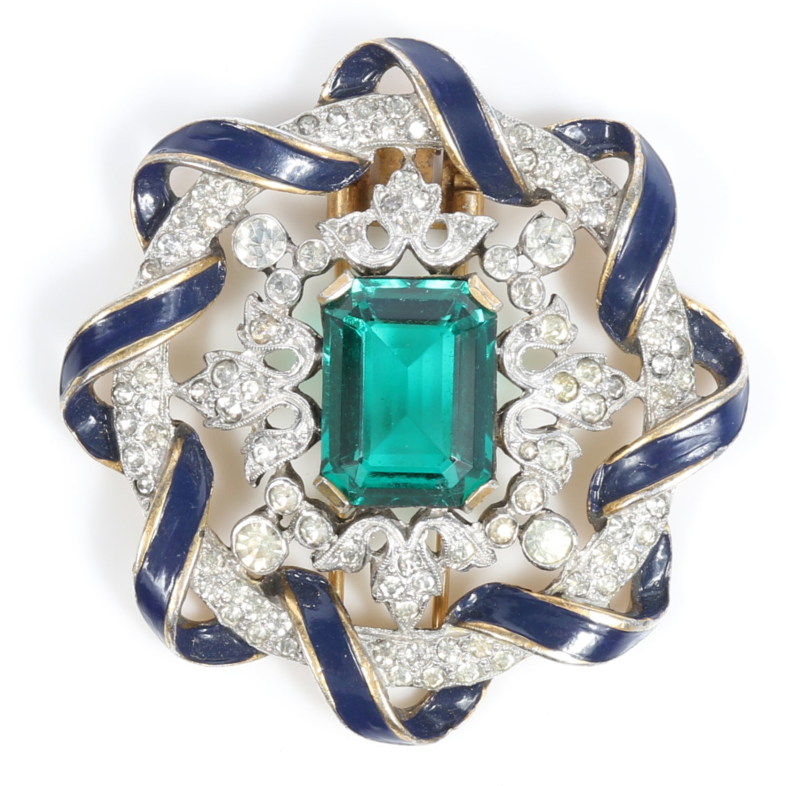 Trifari Alfred Philippe Empress Eugenie fur clip with green center jewel surrounded by navy enamel: Trifari Alfred Philippe Empress Eugenie fur clip with green center jewel surrounded by navy enamel ribbon and rhinestone crystals . 2"H x 2"W