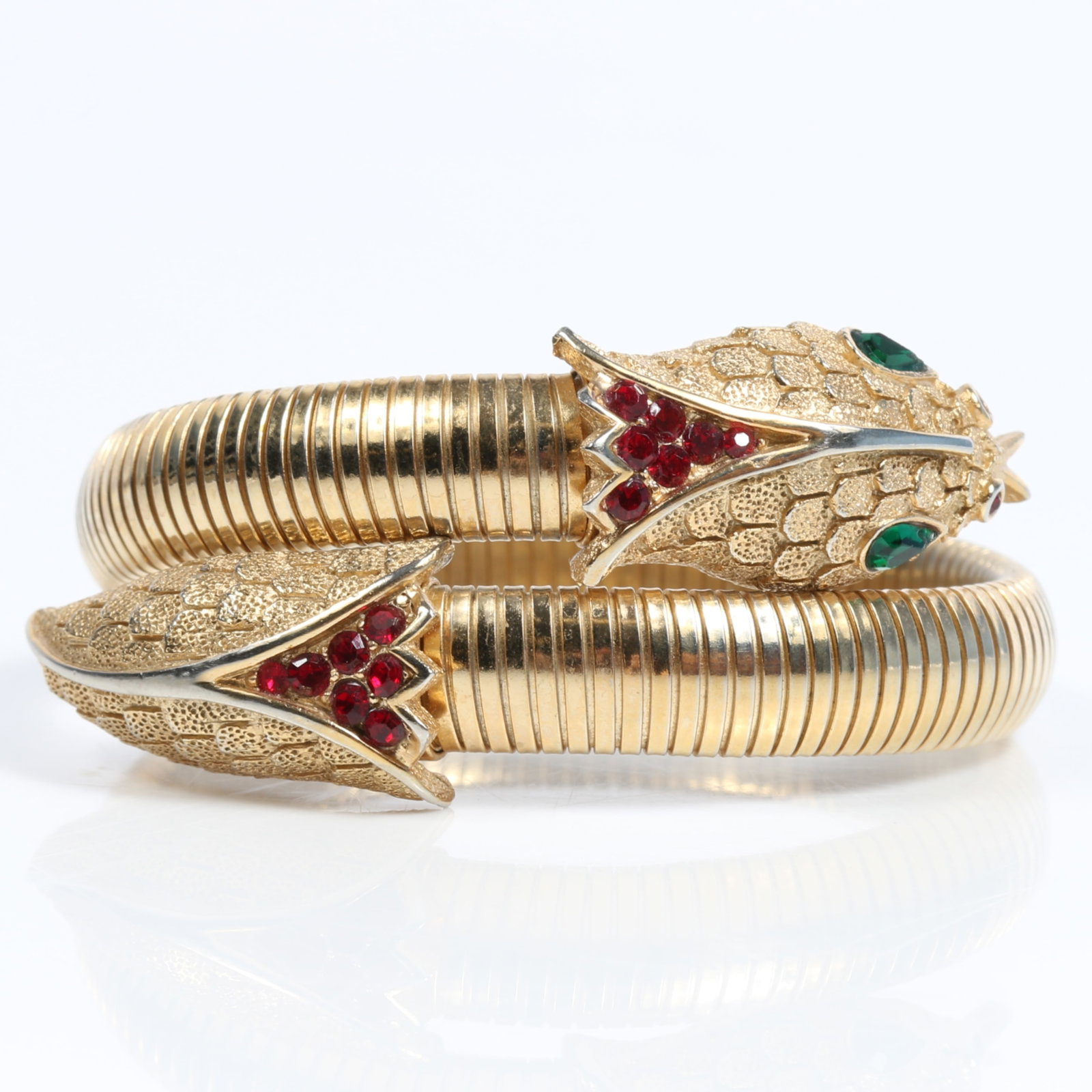 Trifari Egyptian revival snake wrap adjustable coil bracelet with red and green rhinestone crystals: Trifari Egyptian revival snake wrap adjustable coil bracelet with red and green rhinestone crystals . 1"W (at the top where the two parts of the bracelet overlap) x 2 3/8"Inner Dimen. and is expandabl
