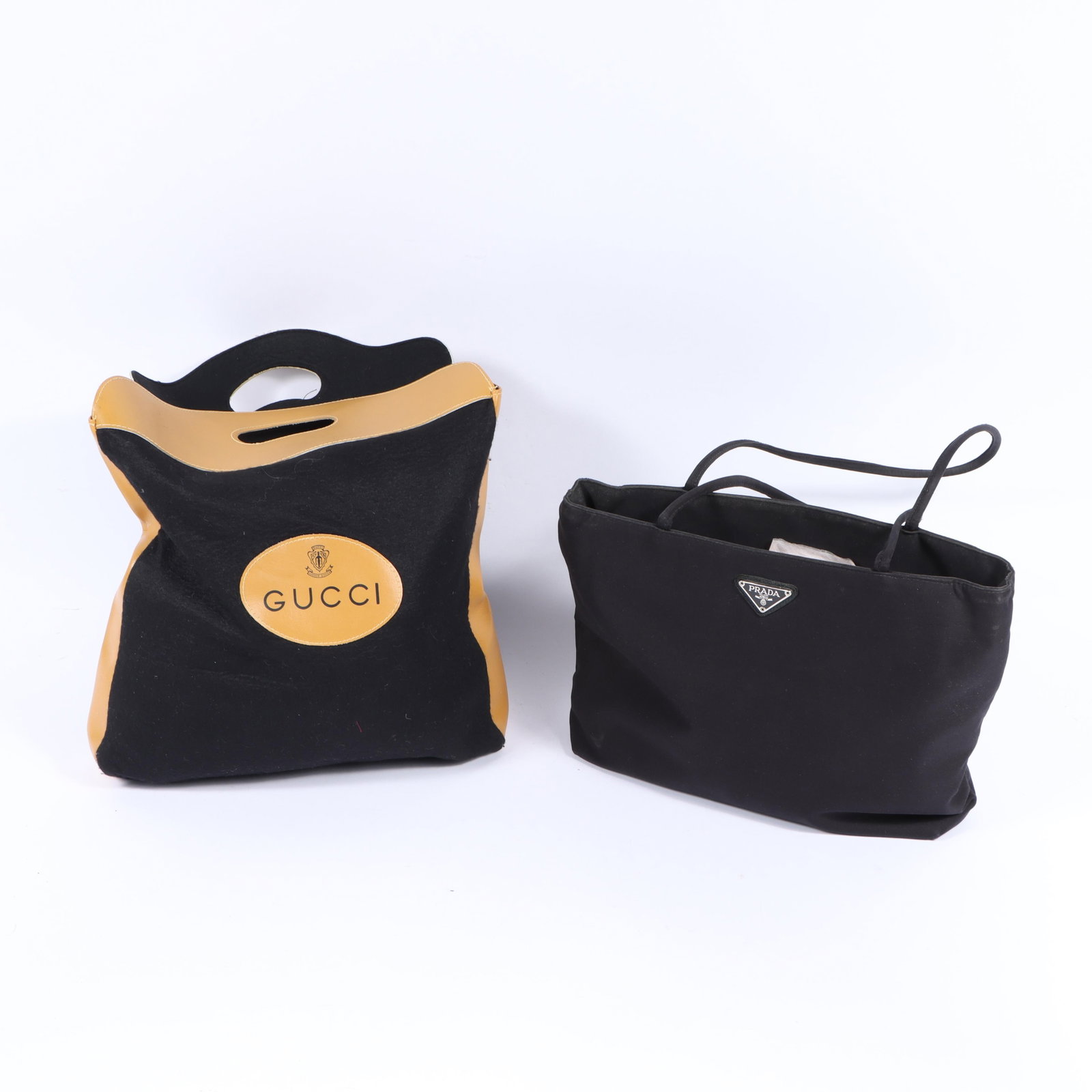 Two designer bags including a Gucci felt and leather shopping bag and a Prada tote bag 11"H x 14: Two designer bags including a Gucci felt and leather shopping bag and a Prada tote bag Prada bag shows wear and use. 11"H x 14 1/2"W(body), 11"Strap drop - Prada bag measured