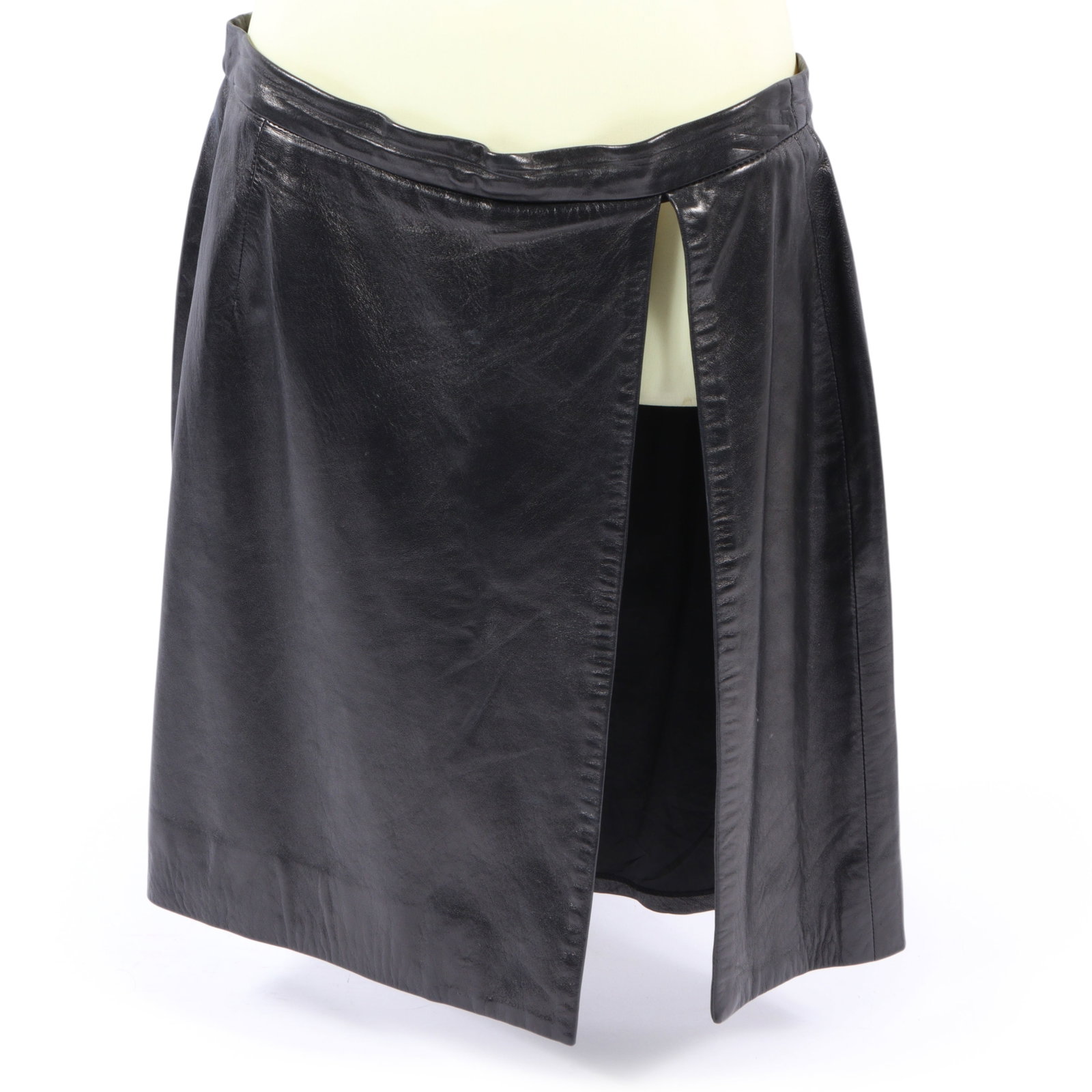 Michael Kors black leather mini skirt 14 1/2" waist, 21" across hem, 19 1/2" hip hem length; Size 10: Michael Kors black leather mini skirt A Michael Kors leather skirt, featuring a sleek and shiny finish. The skirt is designed with a wrap style look and a very high slit to one side. Missing interior 