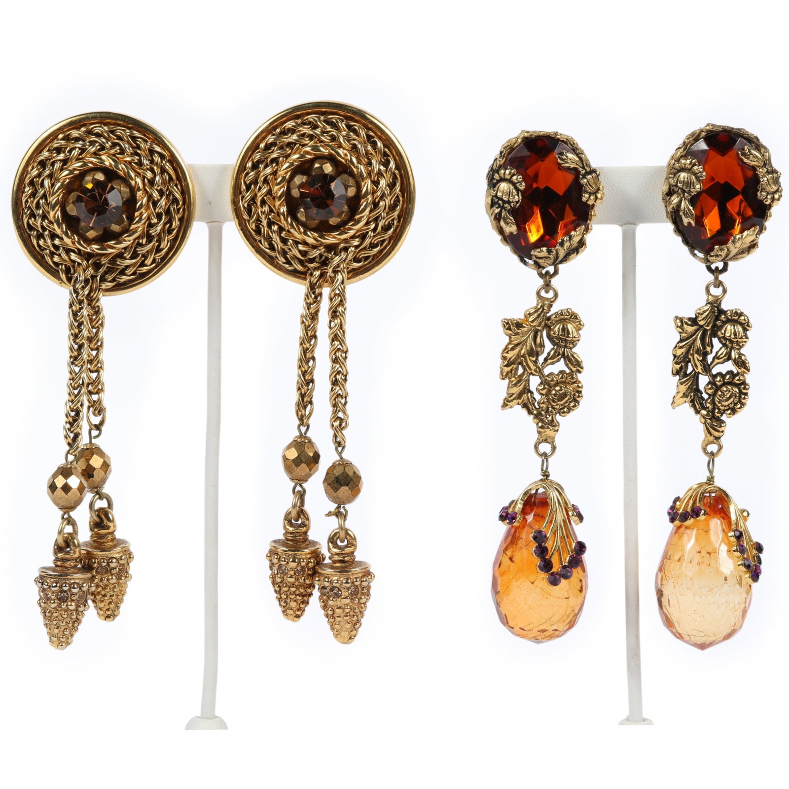 Two pairs of gold-tone designer statement dangle clip-on earrings 7/8"D x 5"L x 1 3/4"W (round: Two pairs of gold-tone designer statement dangle clip-on earrings One pair featuring circular, braided rope-twist design, topaz jewel, with hanging chain tassels and textured bead drops. Also included