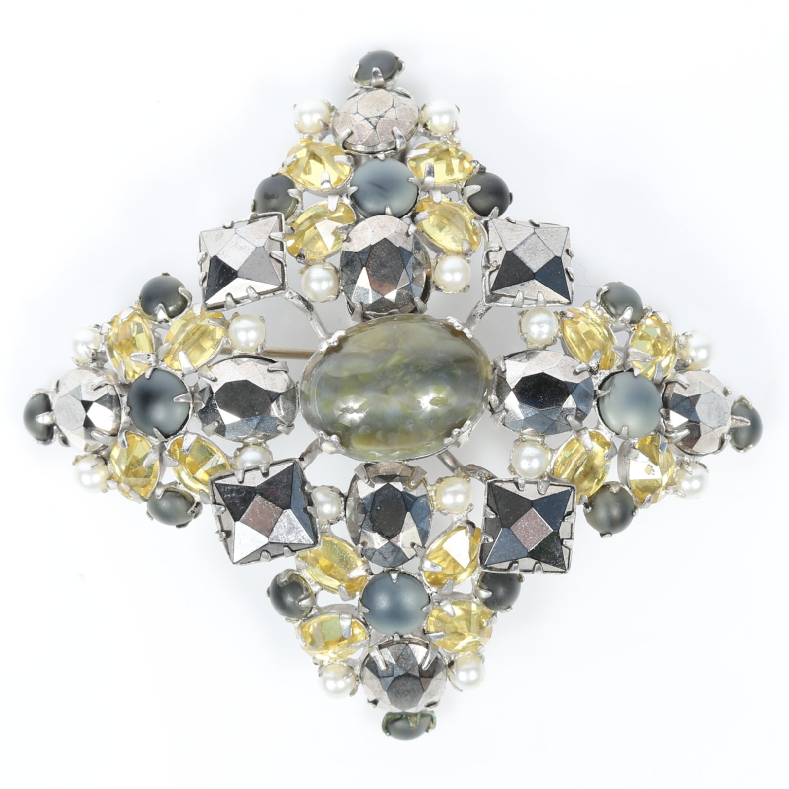 Schreiner New York domed Maltese cross brooch with art glass center cabochon, reverse set jonquil: Schreiner New York domed Maltese cross brooch with art glass center cabochon, reverse set jonquil yellow jewels, and faux hematite stones Provenance: From the Collection of Joan Duran, owner of The Qu