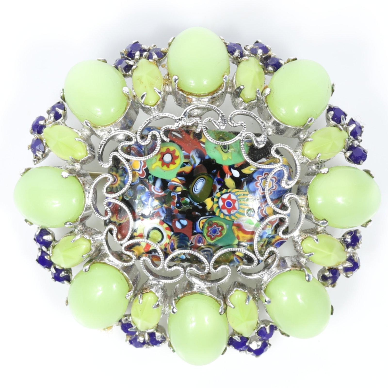 Schreiner New York millefiori glass brooch surrounded by iridescent green moonglow cabochons and: Schreiner New York millefiori glass brooch surrounded by iridescent green moonglow cabochons and sapphire blue crystals. Center left metal finding pattern has one broken spot, one back prong missing P