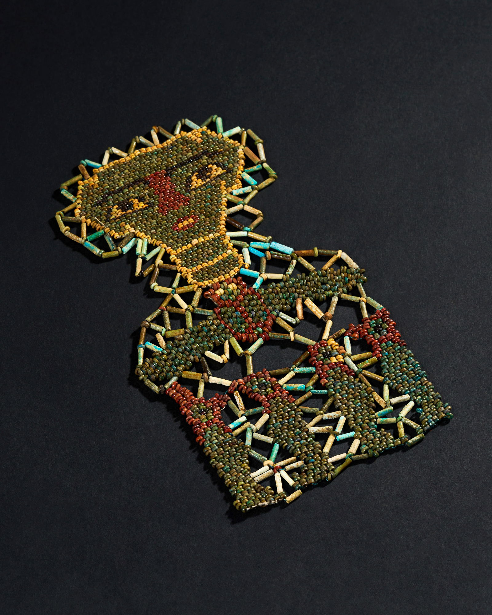 A FAIENCE BEADS MUMMY MASK FROM ANCIENT EGYPT, DATING BACK TO THE LATE PERIOD (664â€“332 BCE): The intricate design features the iconic imagery of the Four Sons of Horus, protectors of the organs of the deceased, and a beautifully crafted winged scarab, symbolizing rebirth and protection in the