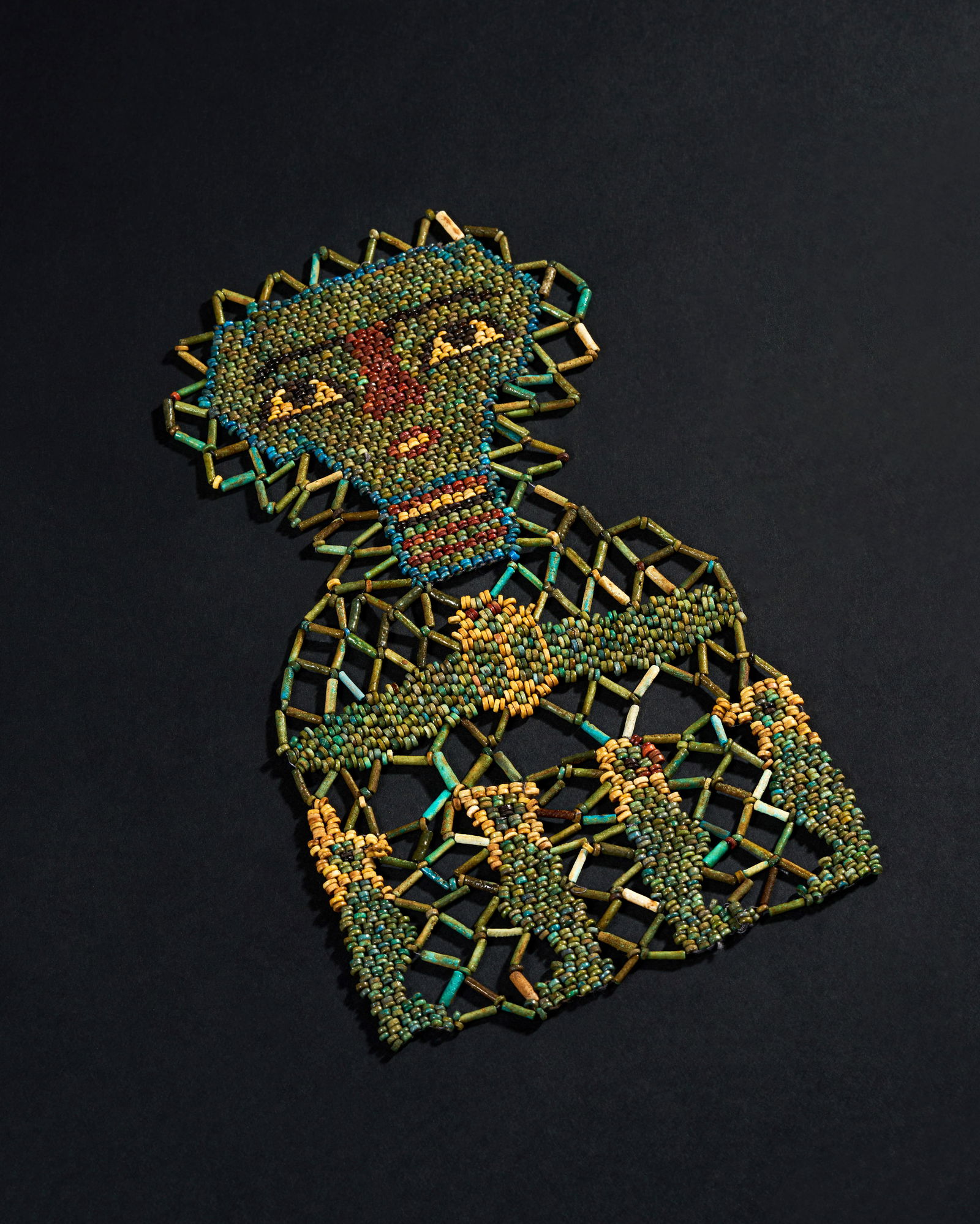 ANCIENT EGYPTIAN FAIENCE BEADS MUMMY MASK, LATE PERIOD (664â€“332 BCE): The intricate design features the iconic imagery of the Four Sons of Horus, protectors of the organs of the deceased, and a beautifully crafted winged scarab, symbolizing rebirth and protection in the