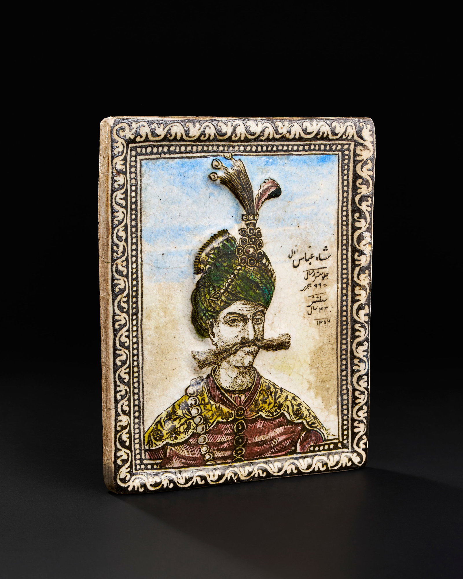A QAJAR MOULDED POTTERY TILE DEPICTING SHAH ABBAS THE GREAT, PERSIA, DATED AH 1317/ AD 1899-1900 (1 of 4)