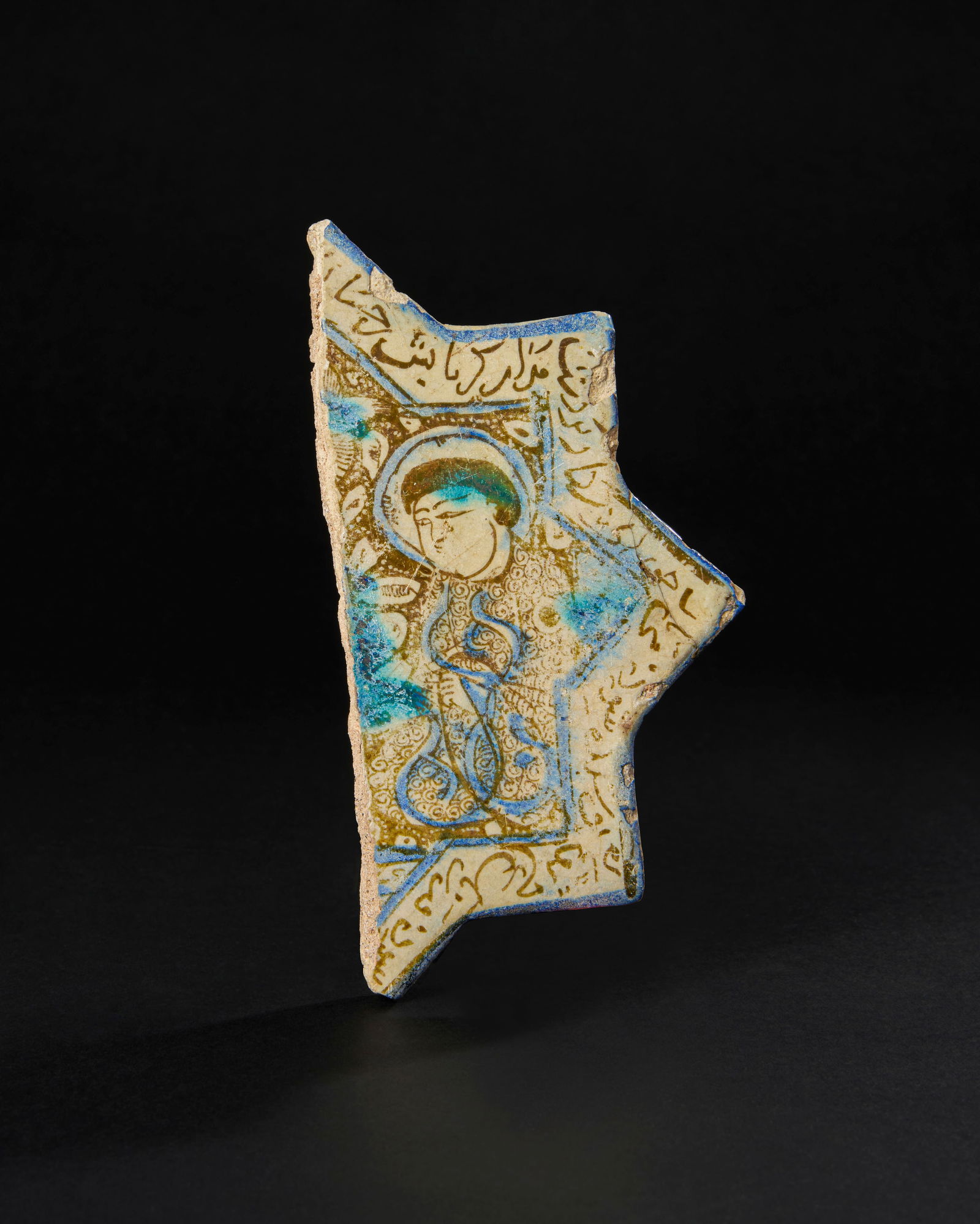 A FRAGMENTARY KASHAN LUSTRE STAR TILE, PERSIA, 12TH/ 13TH CENTURY:  A fragmentary Kashan lustre star tile decorated in a golden-yellow lustre with a seated figure. H: 19.5cm