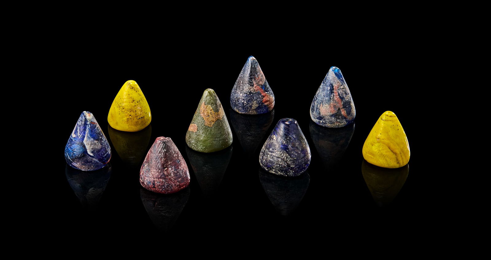 A COLLECTION OF EIGHT POSSIBLY EARLY ISLAMIC GLASS GAMING PIECES (1 of 5)