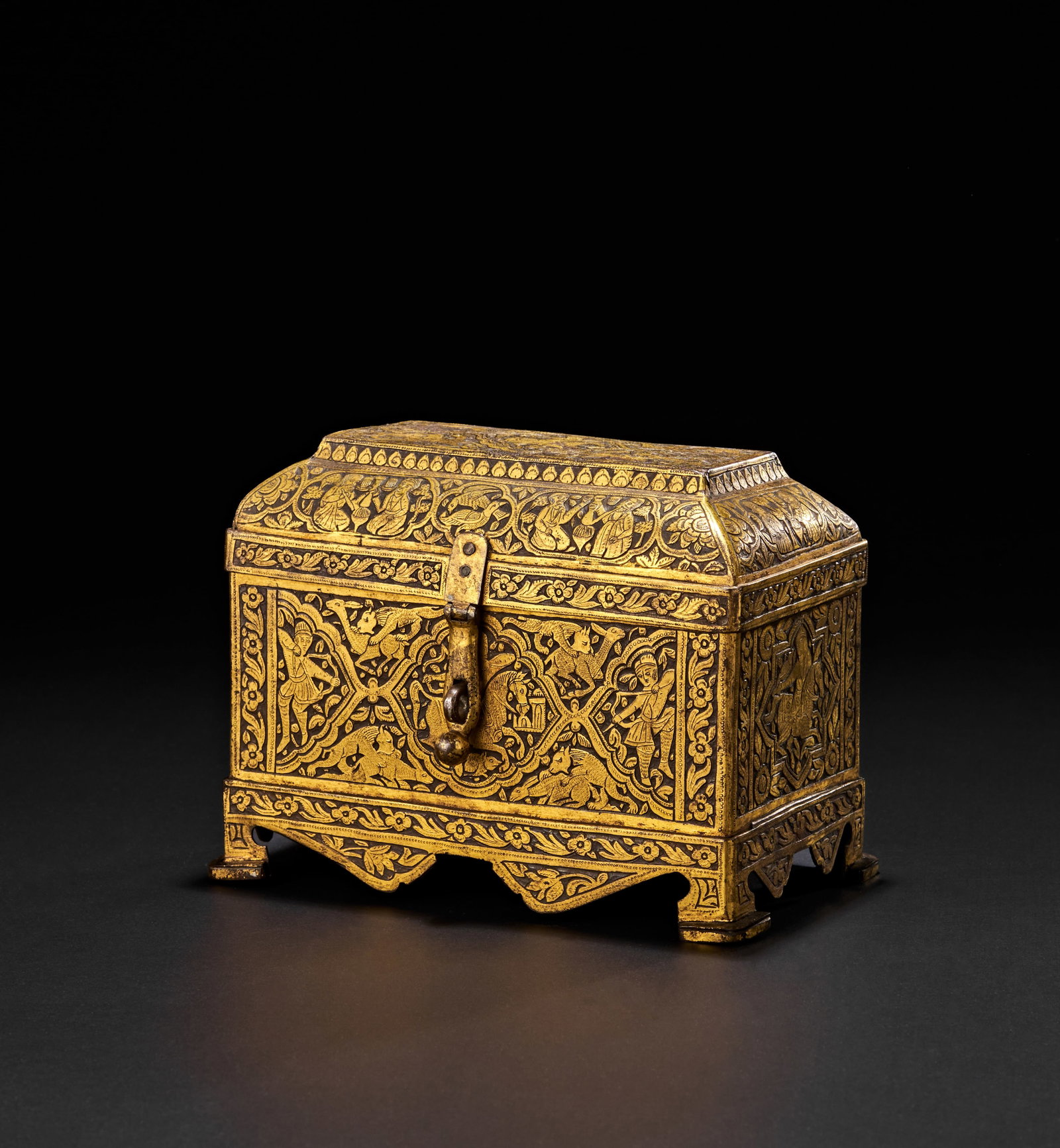 A FINE QAJAR ENGRAVED GOLD OVERLAID STEEL CASKET, PERSIA, 19TH CENTURY: Decorated with intricate overlaid gold designs featuring human figures, animals, and floral motifs, with domed lid and flaring footed base. 13cm x 18cm x 11cm