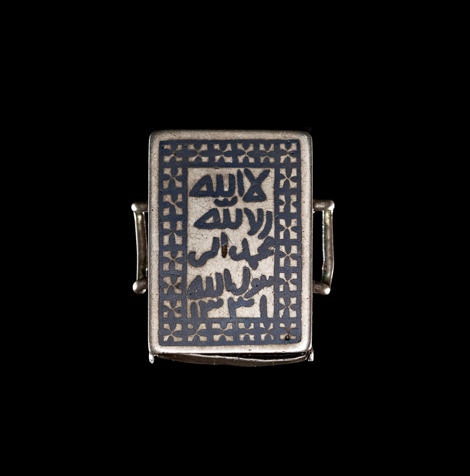A SILVER AND NIELLO AMULET HOLDER, PROBABLY IRAQ, DATED 1331 AH (1 of 3)