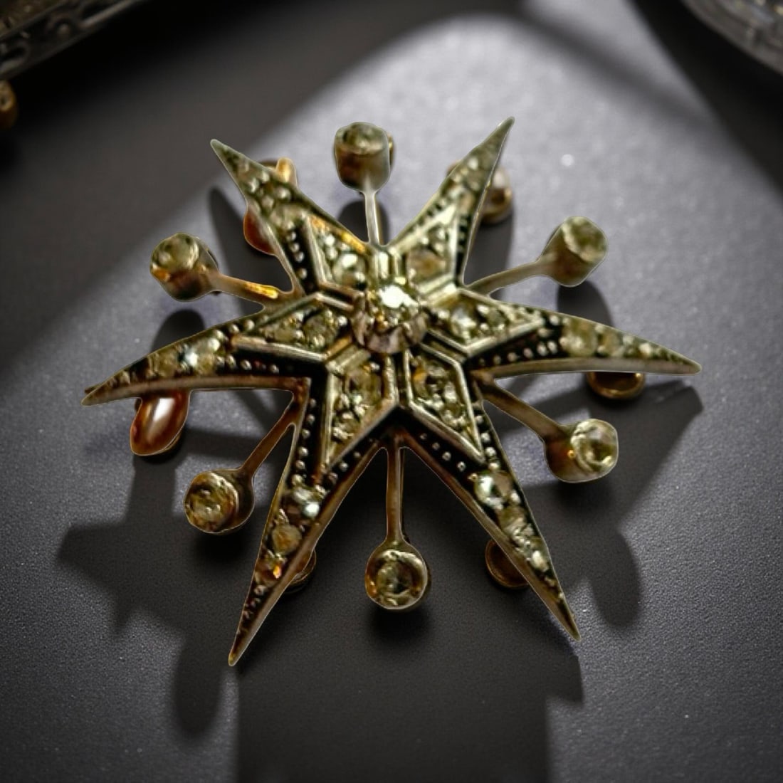 Victorian yellow/white metal star pendant/brooch with diamonds: Tests as 9ct gold and silver. Central old cut diamond surrounded by small rose cut diamonds. Condition: Good but one rose cut diamond is missing Gross weight: 8g approx. Size: Diameter 37mm approx.