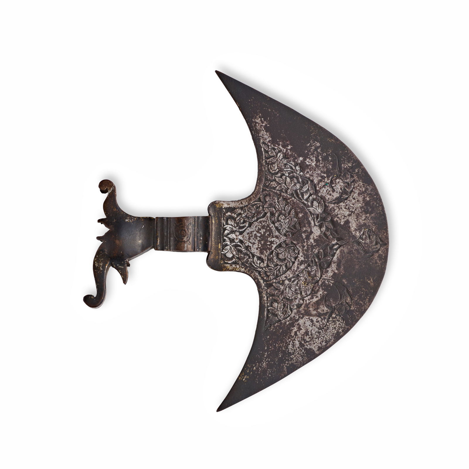 A QAJAR INDO-PERSIAN CHISELED STEEL TABARZIN AXE HEAD, 19TH CENTURY: This Indo-Persian crescent-shaped axe head, known as a tabarzin, is crafted from chiseled steel and reflects the decorative style of the Qajar period. The blade features intricate floral and foliate m