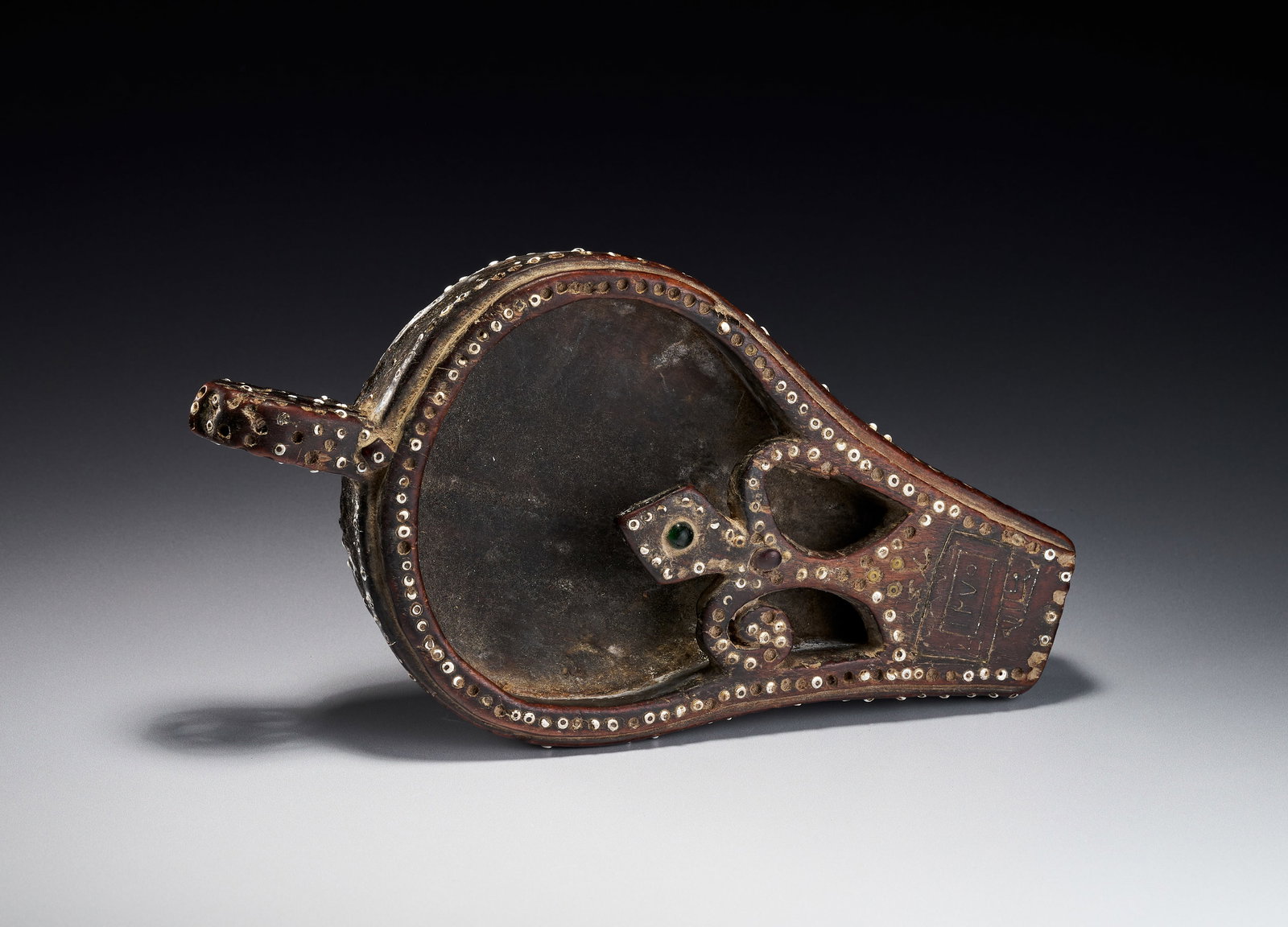 AN OMANI INLAID WOOD COFFEE BEAN COOLER DATED 1275 AH: This Omani coffee beans cooler is fashioned in the form of a miniature bellows and is dated 1275 AH, corresponding to approximately 1858-1859 AD. The piece is carved from dark-stained hardwood and fea