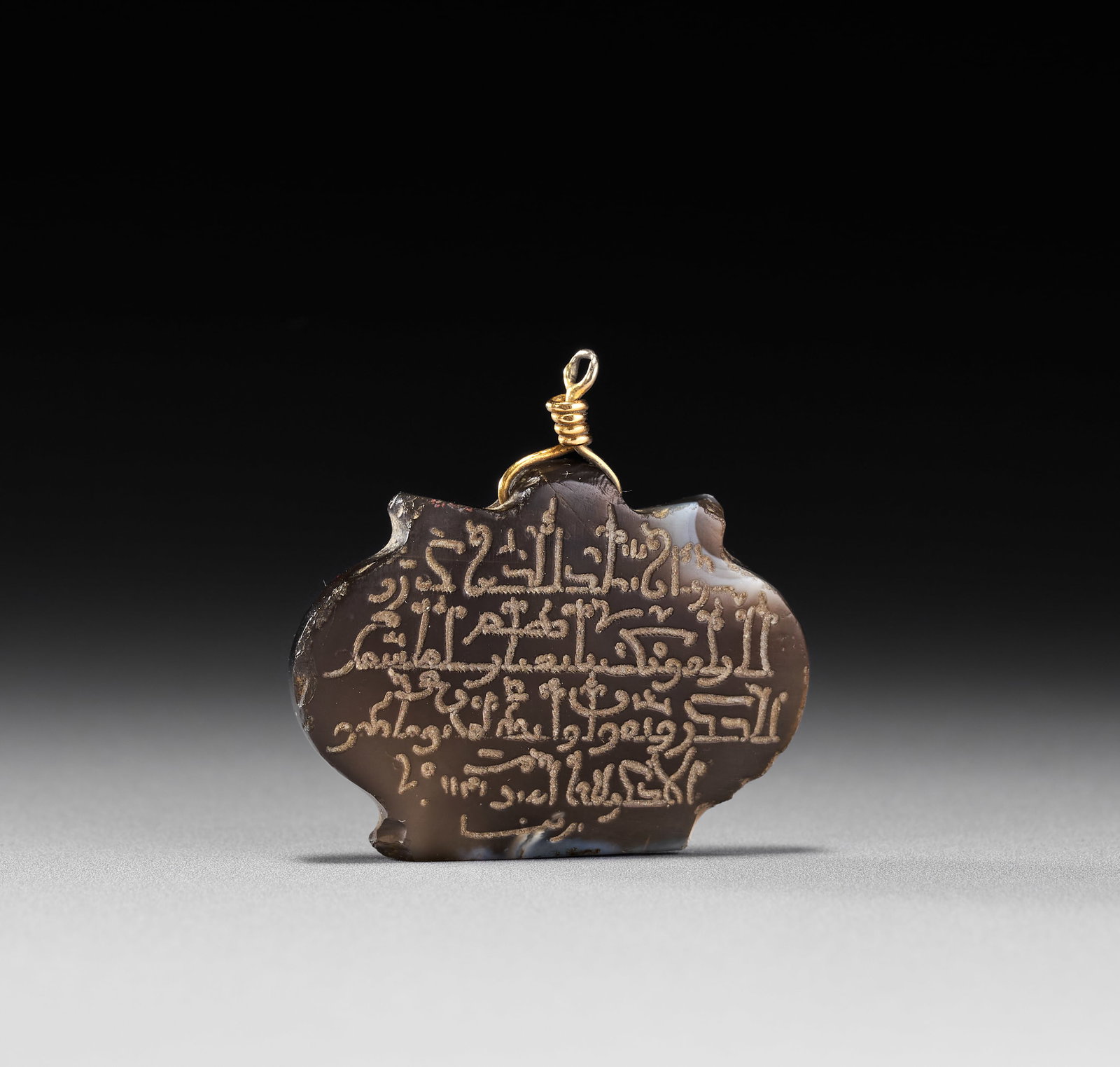 A BANDED AGATE WITH KUFIC TALISMANIC INSCRIPTION PENDANT, 18TH-19TH CENTURY (1 of 2)