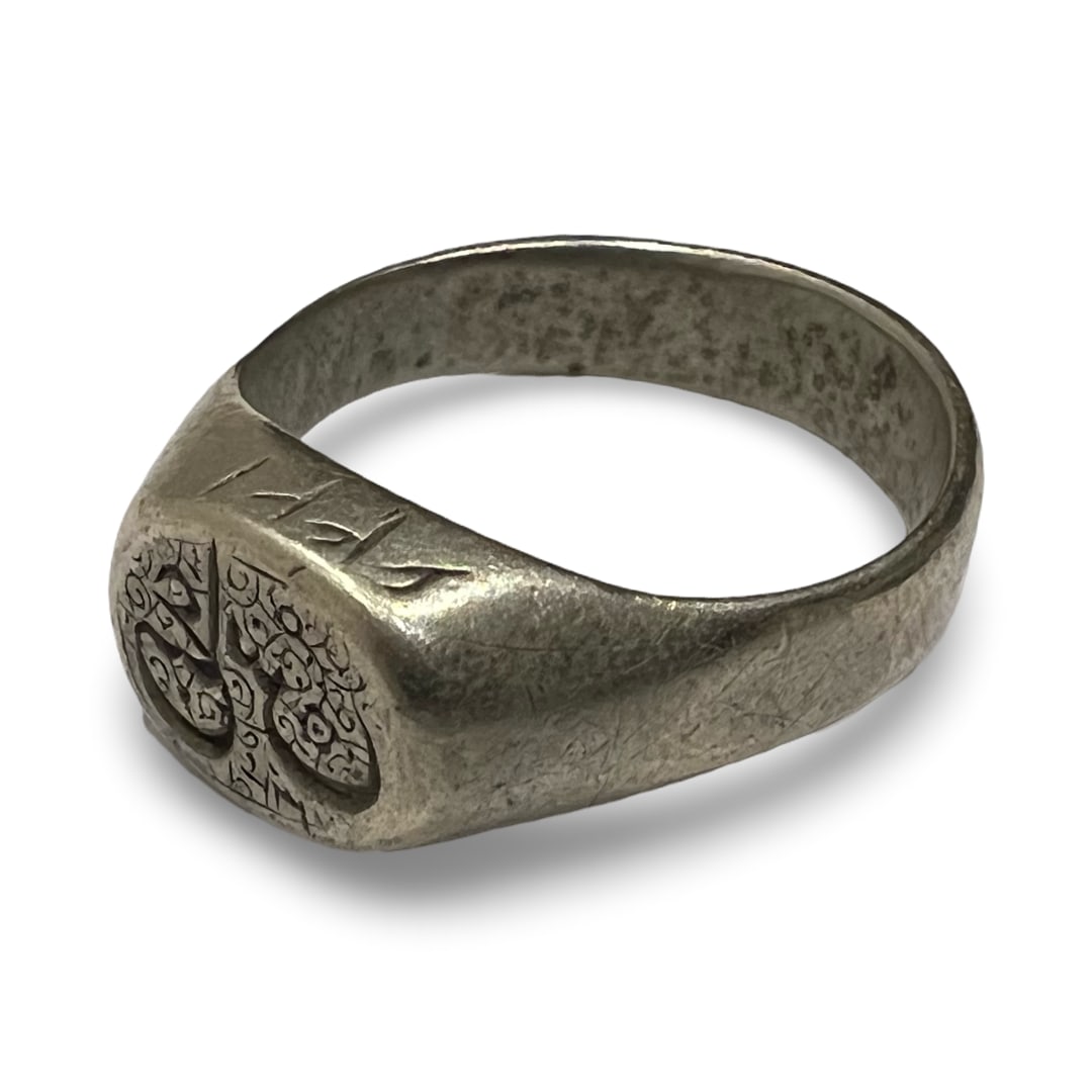 A SILVER-TONED SIGNET RING WITH ENGRAVED MOTIF AND RUNIC STYLE SHOULDER MARKS (1 of 3)