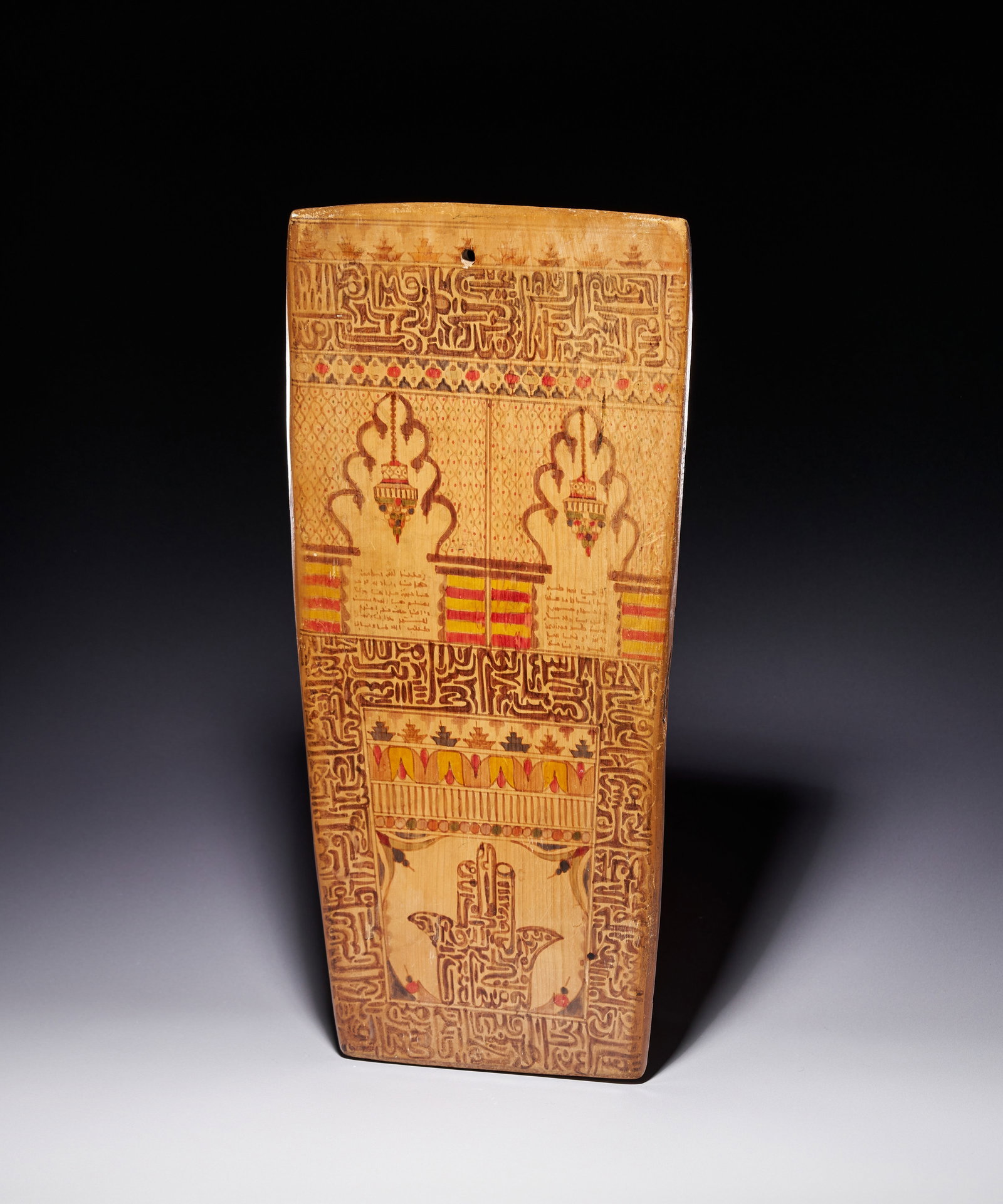 A NORTH AFRICAN POLYCHROME PAINTED WOODEN QURANIC TABLET, 19TH CENTURY: A traditional North African Quranic school board, known as a Luh or Lawh, of the type used for memorisation in the Maghreb region. The tablet is constructed from a single slab of light-coloured wood, 