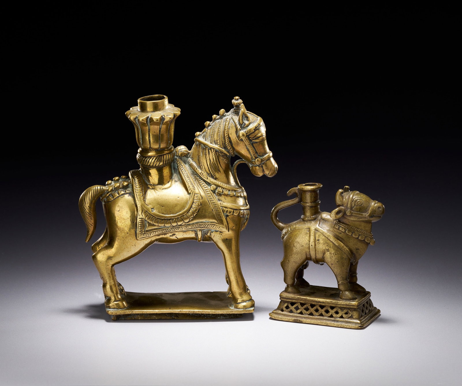 TWO INDIAN FOLK ART CAST BRASS ANIMAL FIGURINES, MAHARASHTRA OR DECCAN, 18TH CENTURY: TWO INDIAN FOLK ART CAST BRASS ANIMAL FIGURINES, MAHARASHTRA OR DECCAN, 19TH CENTURY The horse figurine features a detailed bridle and a saddlecloth decorated with tassels and bead-like studs. Mounted