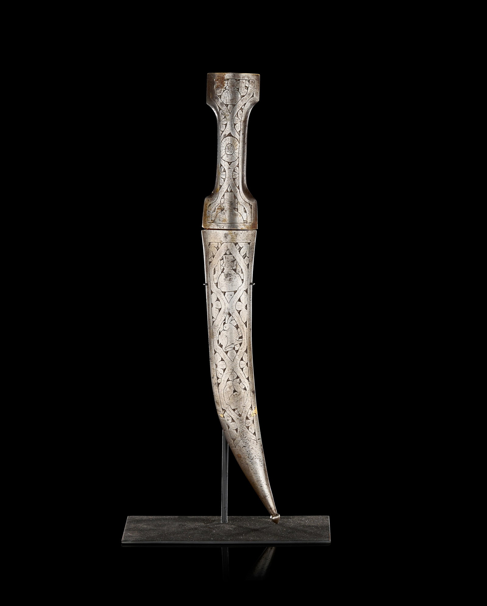 A QAJAR STEEL DECORATED KHANJAR DAGGER AND SCABBARD, PERSIA,19TH CENTURY: The dagger comprises a curved, double-edged blade crafted from a light-coloured organic material, possibly bone or horn, showing a natural grain and surface patination. The hilt is of traditional I-sh