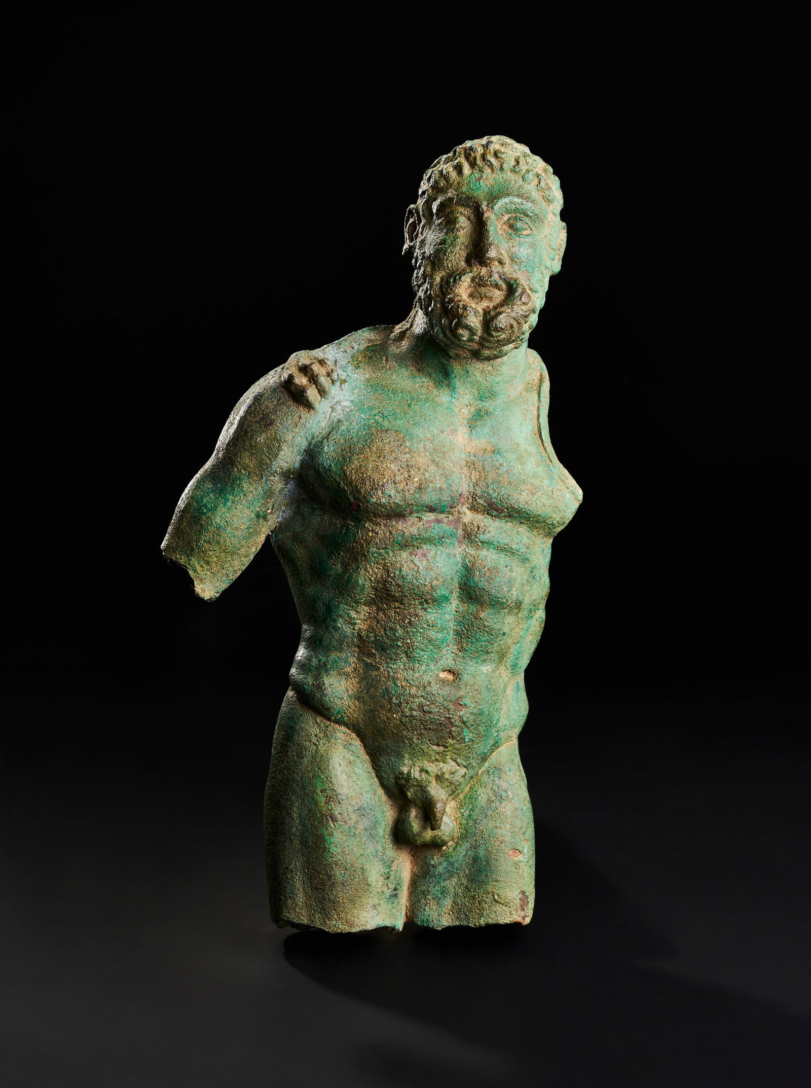 A LARGE FRAGMENTAL BRONZE TORSO FIGURE OF HERCULES: A hollow-cast bronze sculpture depicting the muscular torso of the mythological hero Herakles. The figure is identified by the attribute of a Nemean lion's paw resting upon the right shoulder. The tor