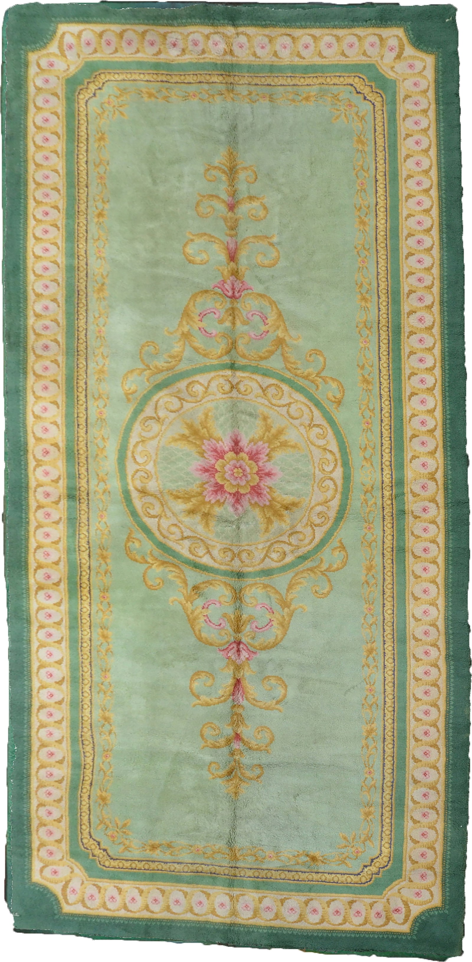 A LARGE VINTAGE HAND-KNOTTED SPANISH CARPET, CIRCA 1950S: This large hand-knotted wool carpet is of Spanish origin and dates to circa 1950s. The rug is designed in the Savonnerie style, featuring a central circular floral medallion with a multi-petalled pink