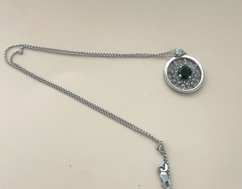 LOVELY 10KT WHITE G . DIAMOND & TSAVORITE NECKLACE: 16" NECKLACE, 1 CT TSAVORITE, SURROUNDED by small diamonds, total weight 5.5 grams