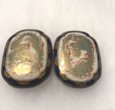 ANTIQUE JAPANESE SATSUMA BELT BUCKLES DRAGONS: Meji period 1868-1912, hand painted ename; and gilded porcelain, featuring a dragon motif, with gold ACCENTS, AND a deep cobalt border, each about 2 1/2" long, mounted on Japanese silver, excellent co