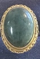 MID CENTURY 18KT Y.G. LARGE OVAL JADE RING: Large oval jade set in 18kt yellow gold, with a twisted rope edge. size 6.5 with a total weight of 5 dwt