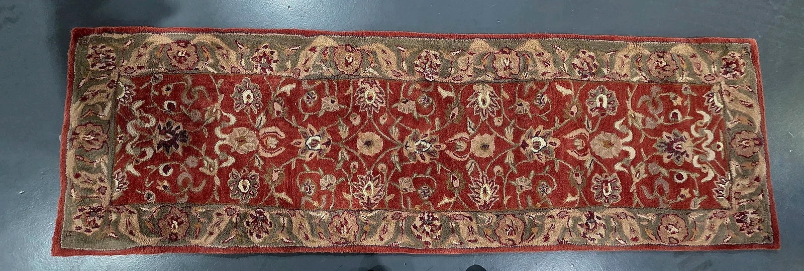Kenneth Mink Floral Pattern Runner Rug: A runner rug by Kenneth Mink featuring a traditional scrolling floral and palmette design set against a red field, enclosed by a coordinating floral border in neutral and earthy tones. The reverse fea