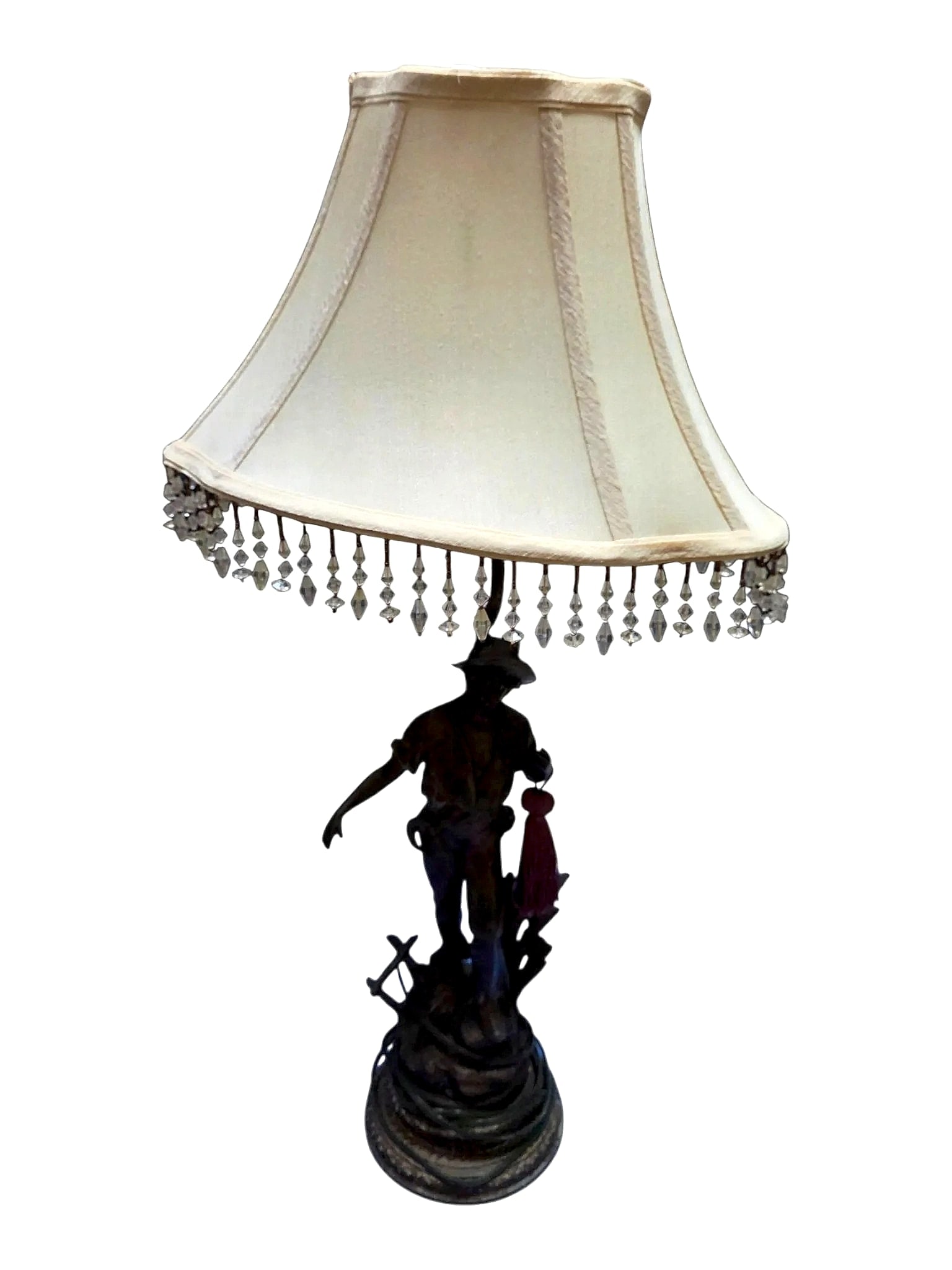 Figural Harvest Farmer Table Lamp with Beaded Fringe Shade: An electric table lamp featuring a sculptural figure of a harvester or farmer dressed in a wide-brimmed hat, open-collar shirt, and rolled sleeves, standing beside sheafs of wheat and a farm implement