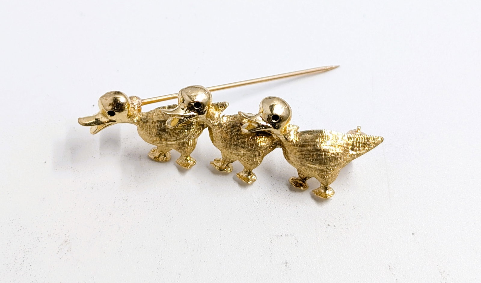 14k Gold 3 Duck Brooch: Metal Content: 14K Gold Weight: 4.56 Grams Size: 1.75in x 0.5in Estimate: $250-$350