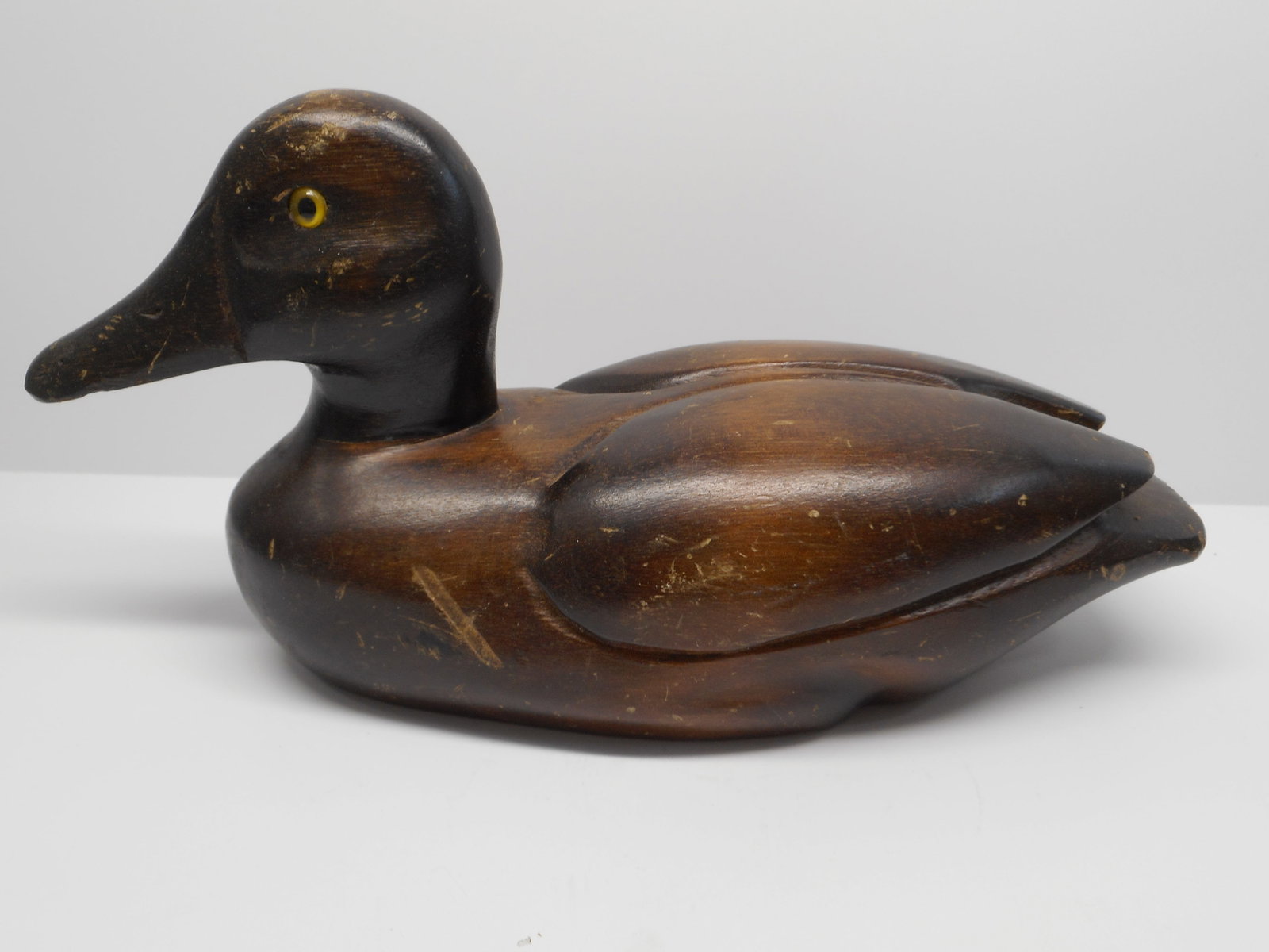 Dark Wood Carved Duck with Yellow Glass Eyes, Home Decor, 10 inches: Bidding on this item will be indication that the Bidder acknowledges that they have read and agreed to the Terms and Conditions posted to this Auction