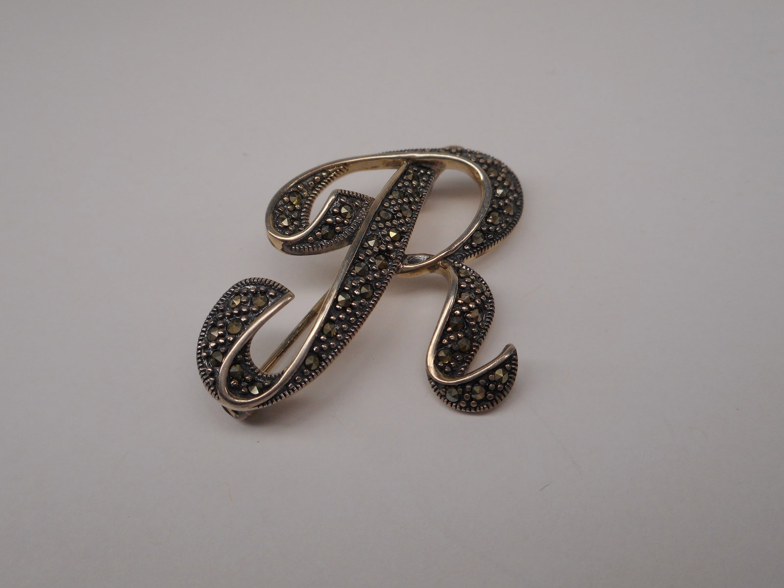 Sterling Silver and Marcasite Monogram "R" Brooch, 1.5 inches: Bidding on this item will be indication that the Bidder acknowledges that they have read and agreed to the Terms and Conditions posted to this Auction