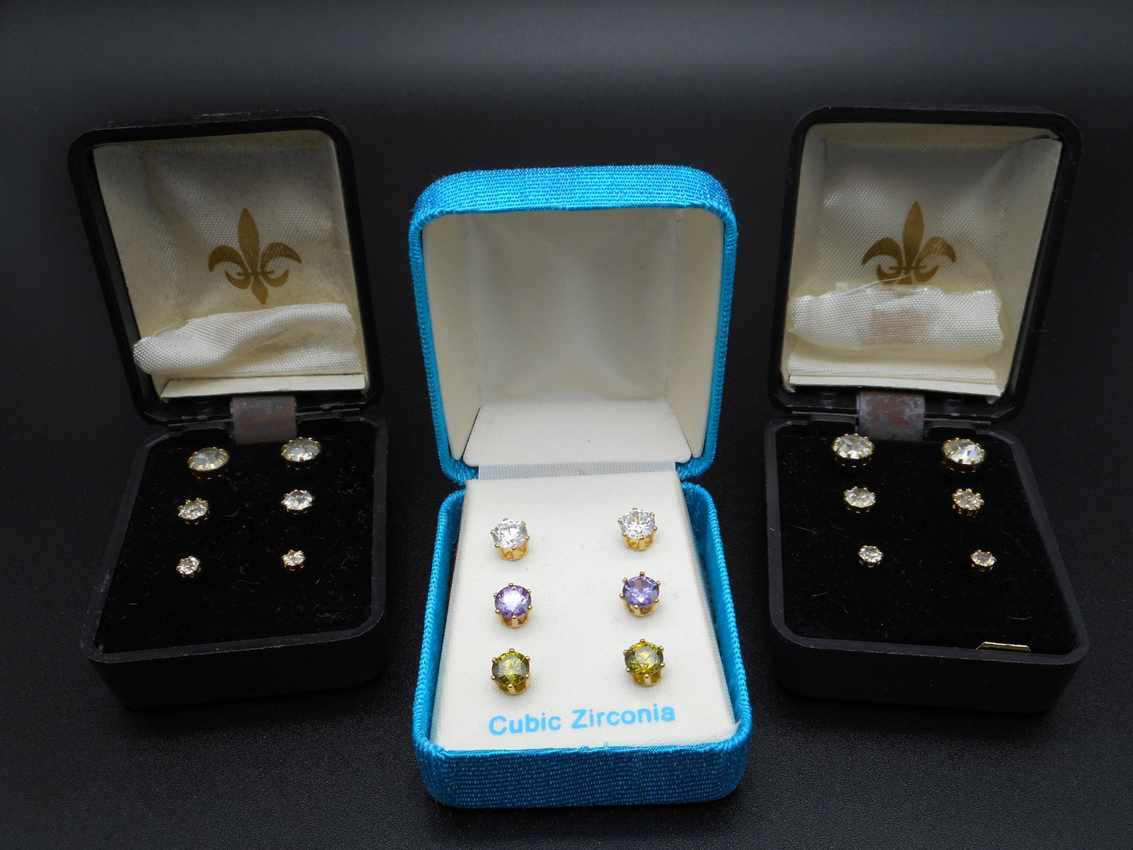 9 pairs of Stud Post Earrings, Colored Cubic Zirconia and Clear Stones, in original boxes: Bidding on this item will be indication that the Bidder acknowledges that they have read and agreed to the Terms and Conditions posted to this Auction
