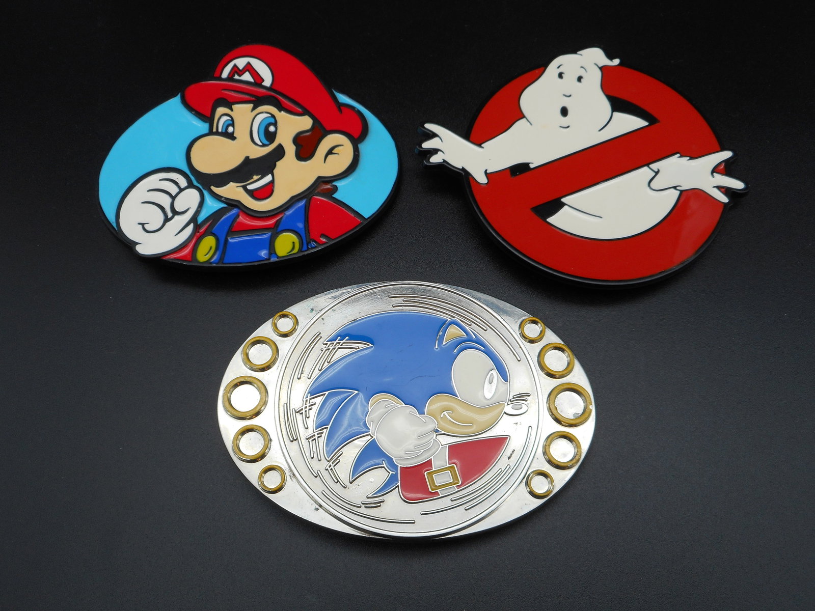 Character Metal and Enamel Belt Buckles - Mario, Ghostbusters Logo, Sonic the Hedgehog (Spins!): Belt buckles are 3.5-4 inches Bidding on this item will be indication that the Bidder acknowledges that they have read and agreed to the Terms and Conditions posted to this Auction