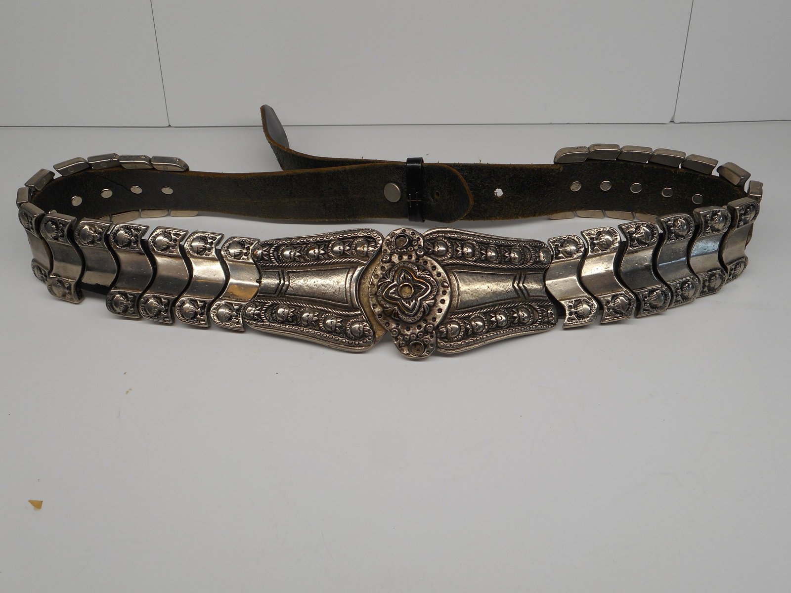 Worn Leather Articulated Silver Etruscan Belt, Adjustable, One Link Broken, About 30 inches long: Bidding on this item will be indication that the Bidder acknowledges that they have read and agreed to the Terms and Conditions posted to this Auction