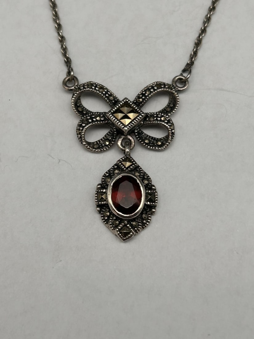 Double Bow Sterling Silver and Marcasite with Garnet Pendant on 16-inch Chain, Marked 925: Bidding on this item will be indication that the Bidder acknowledges that they have read and agreed to the Terms and Conditions posted to this Auction