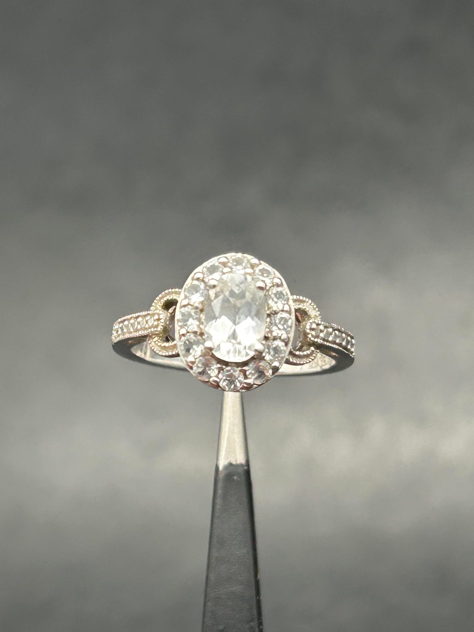 Oval Cut Clear Stone with Halo in Sterling Silver Decorated Setting, Marked 925, Size 7: Bidding on this item will be indication that the Bidder acknowledges that they have read and agreed to the Terms and Conditions posted to this Auction