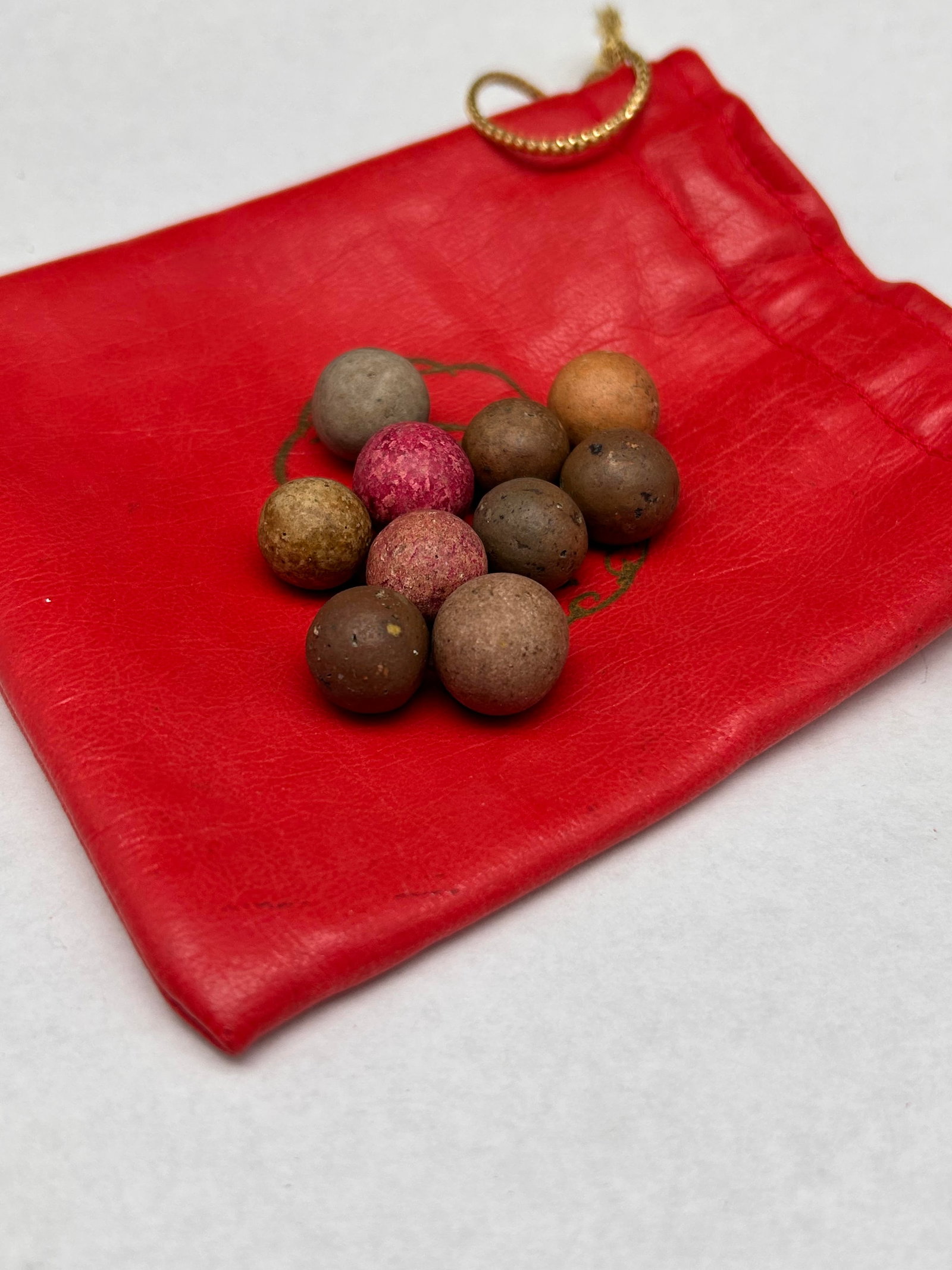 Antique Clay Marbles in 4" Red Leather Drawstring Pounch: Bidding on this item will be indication that the Bidder acknowledges that they have read and agreed to the Terms and Conditions posted to this Auction