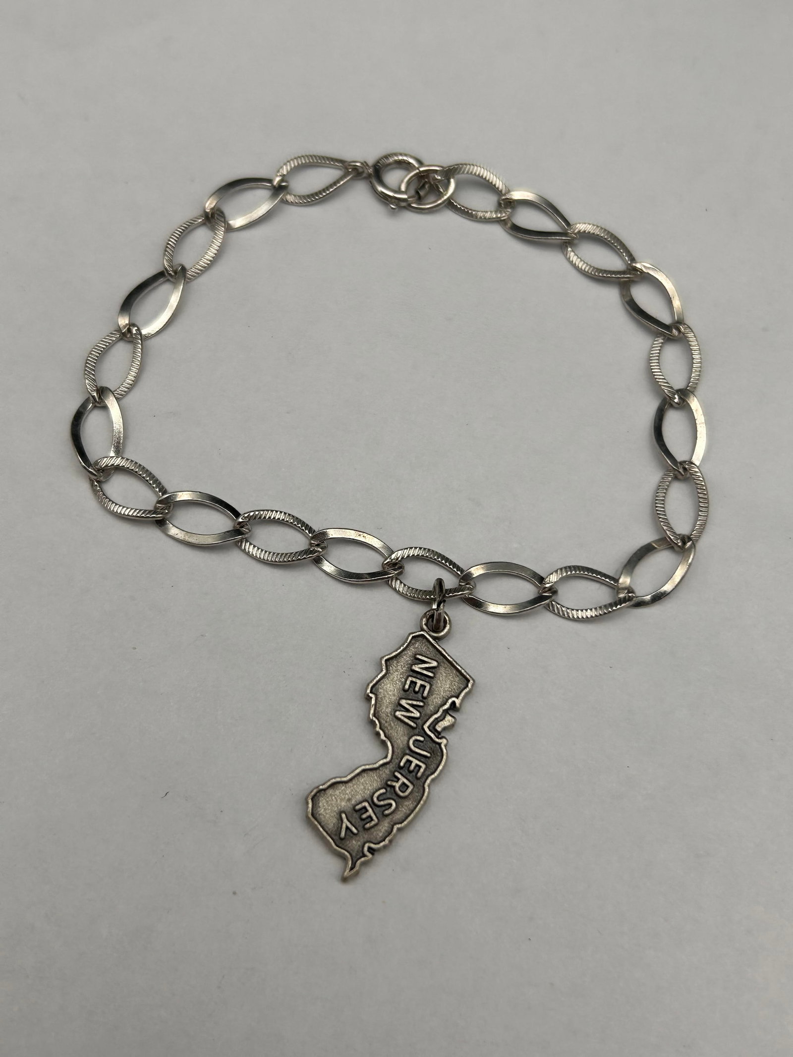 Sterling Silver NJ Garden State 1" Charm and Textured Link Bracelet, 7", Both pieces marked Sterling: Bidding on this item will be indication that the Bidder acknowledges that they have read and agreed to the Terms and Conditions posted to this Auction