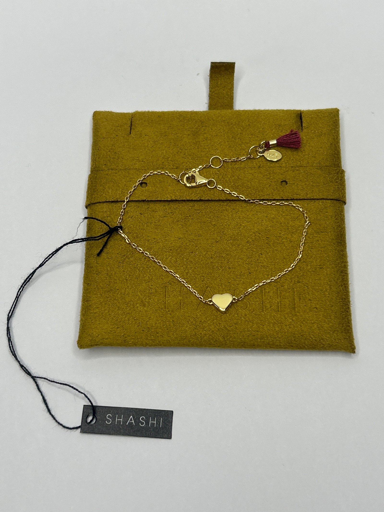 SHASHI Gold Toned 925 Silver Bracelet with Heart Charm and Tassel Accent, Adjustable 6"-7.5": Bidding on this item will be indication that the Bidder acknowledges that they have read and agreed to the Terms and Conditions posted to this Auction