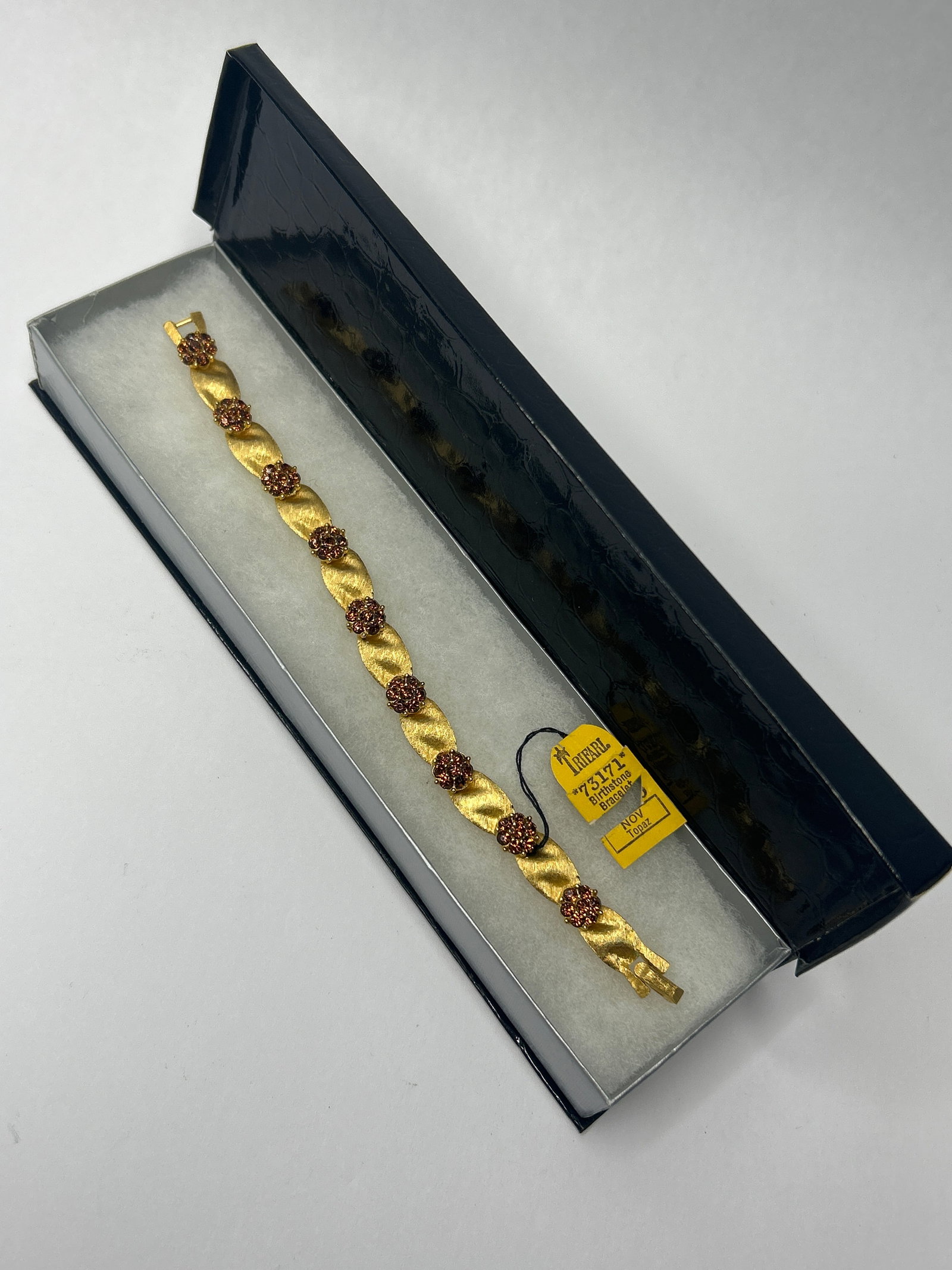 1960s Crown TRIFARI Gold Toned Ribbon Birthstone Bracelet, November, Topaz, 7", with Box: Bidding on this item will be indication that the Bidder acknowledges that they have read and agreed to the Terms and Conditions posted to this Auction
