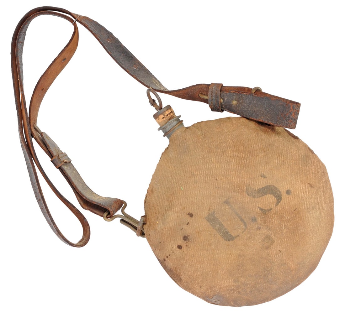 US Military Spanish American War Era Canteen with Cover and Strap(K2C): A US Military Spanish American War Era Canteen with Cover and Strap in good condition. The cover has some moderate staining but maintains good stitching and structure. The leather strap is complete wi