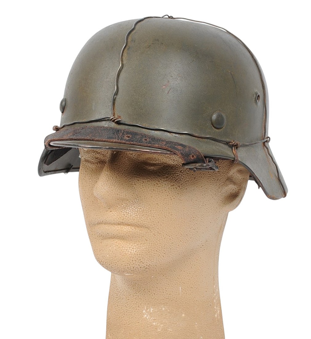 *German WWII "Chicken Wire" M40 Helmet (BM): A *German WWII "Chicken Wire" M40 Helmet in good to very good condition. The helmet maintains very good paint with a nice chin strap and liner. The serial number in the helmet reads "ET68". The